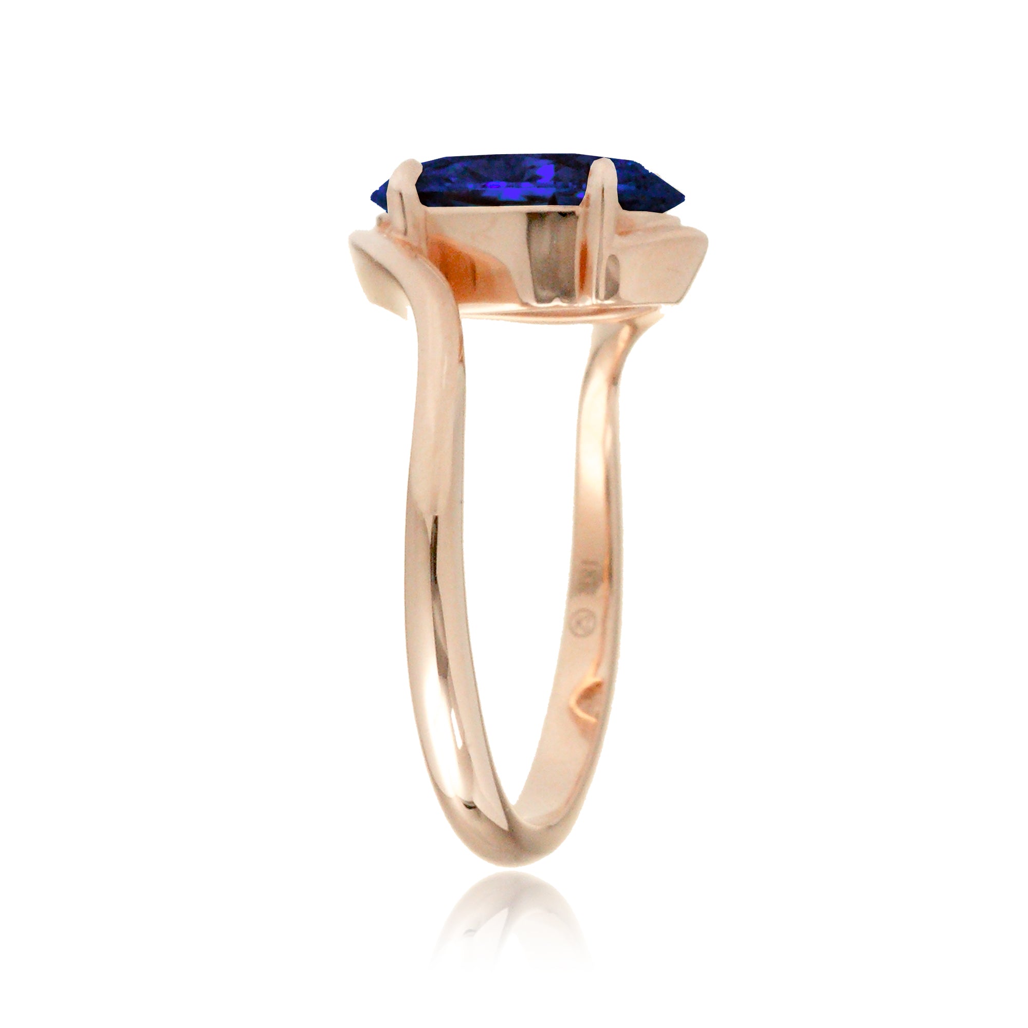 Contemporary oval blue sapphire engagement ring with twisting rose gold band