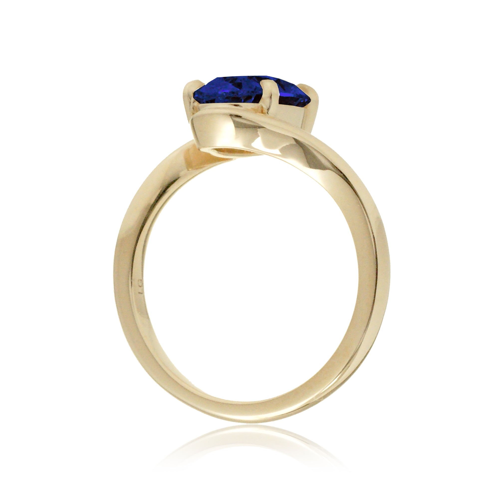 Elegant bypass-style oval sapphire ring with polished yellow gold shank