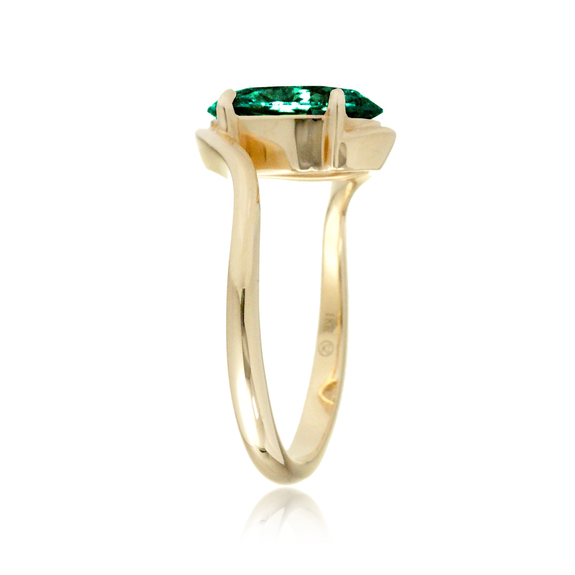Elegant yellow gold bypass ring featuring an oval-cut emerald