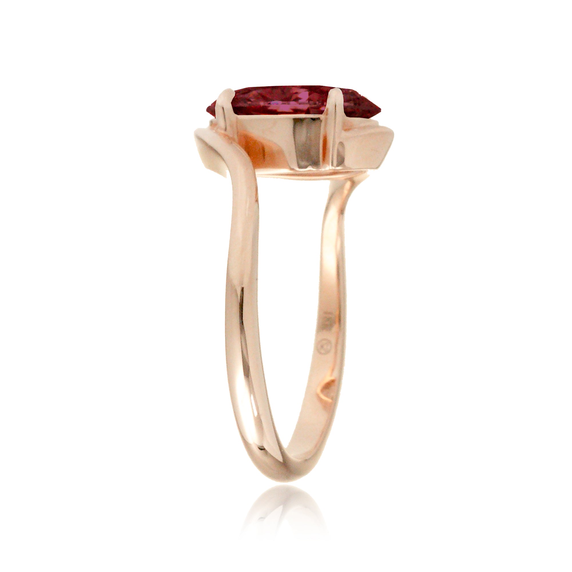 Modern bypass-style ring with deep red oval ruby and rose gold setting