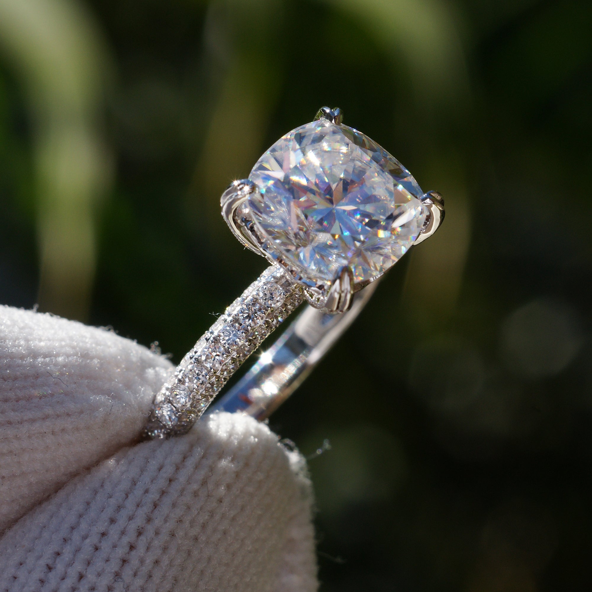Cushion moissanite engagement ring with a pavé diamond band in white gold