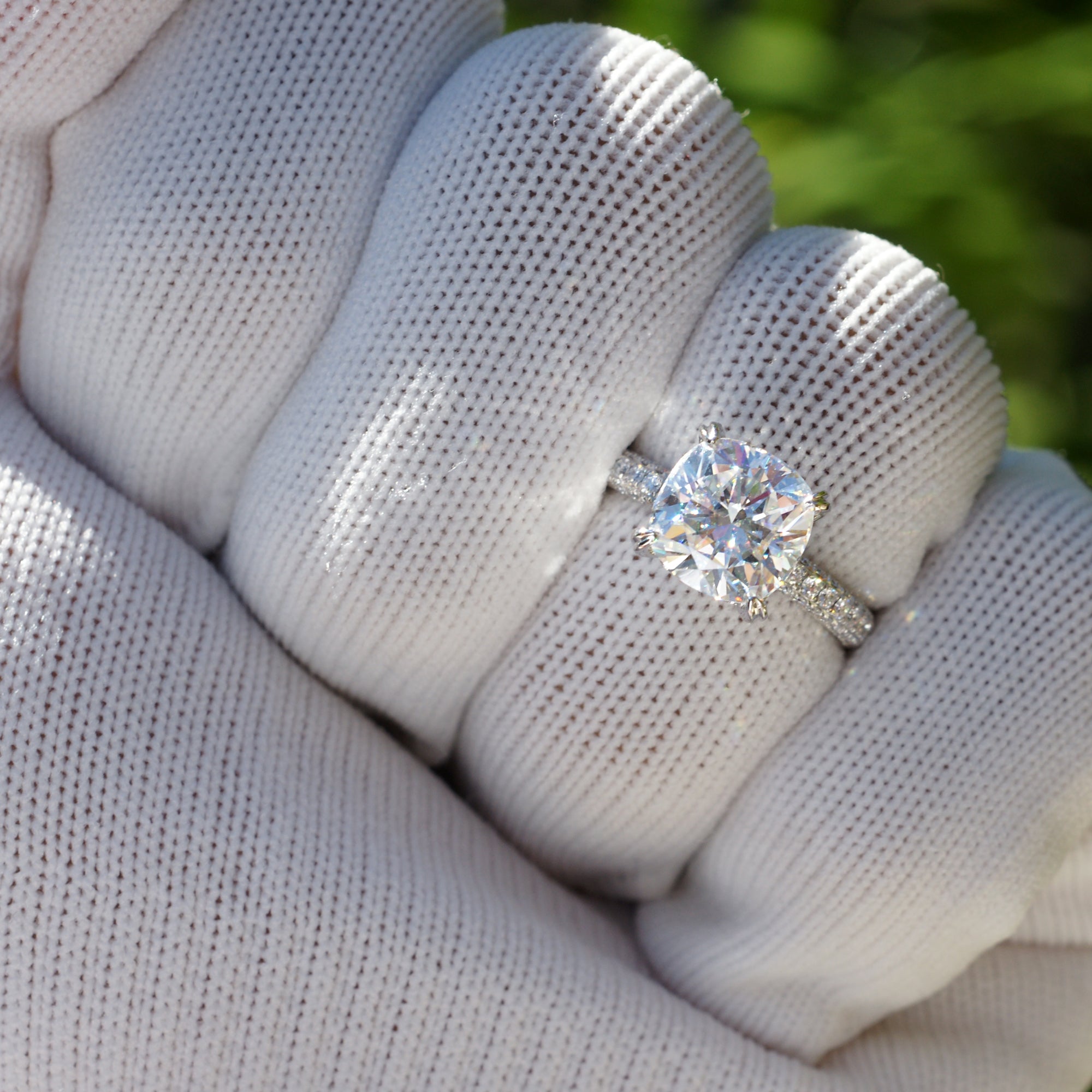 Cushion moissanite engagement ring with a pavé diamond band in white gold