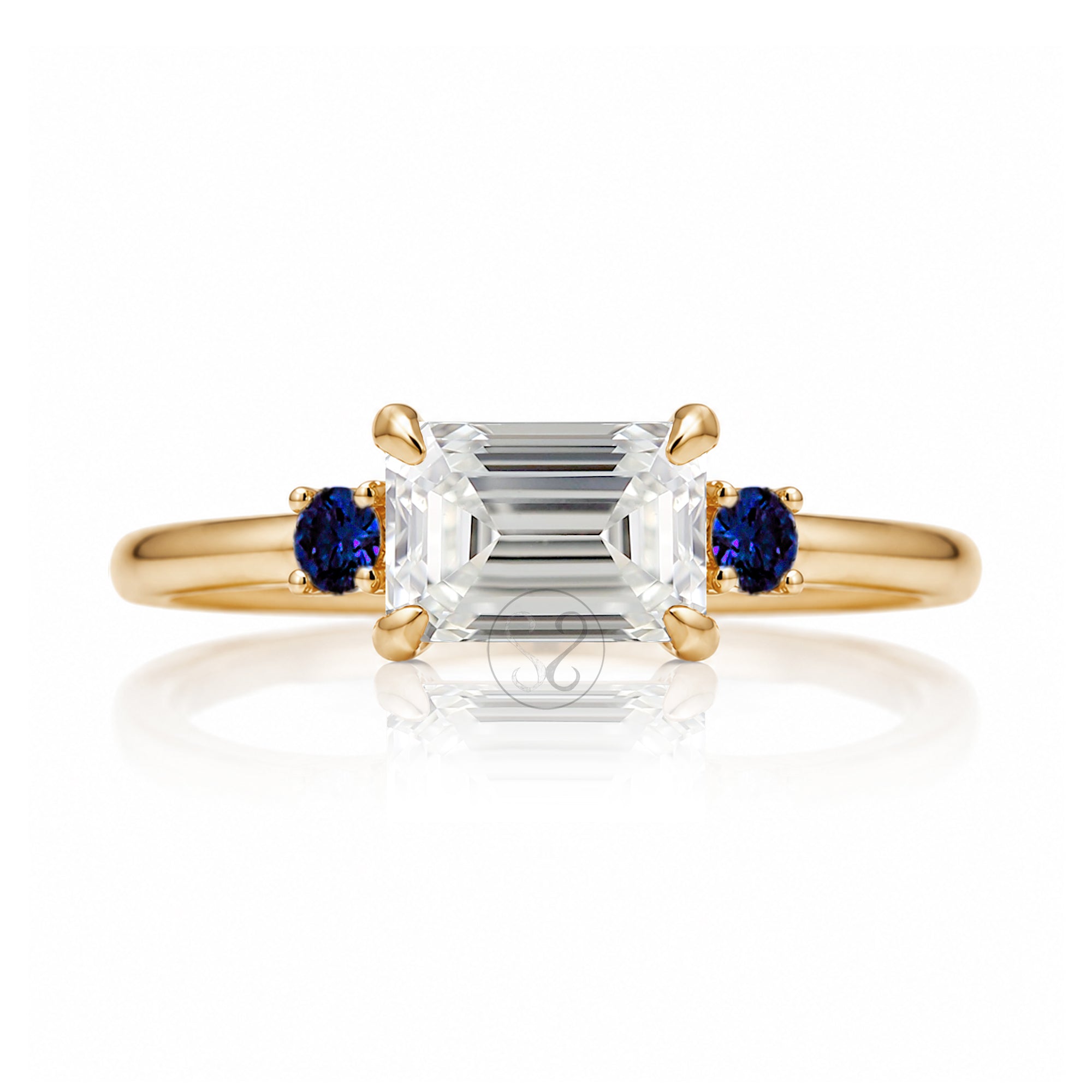 east-west emerald cut diamond three stone ring the Lena with side blue sapphires yellow gold