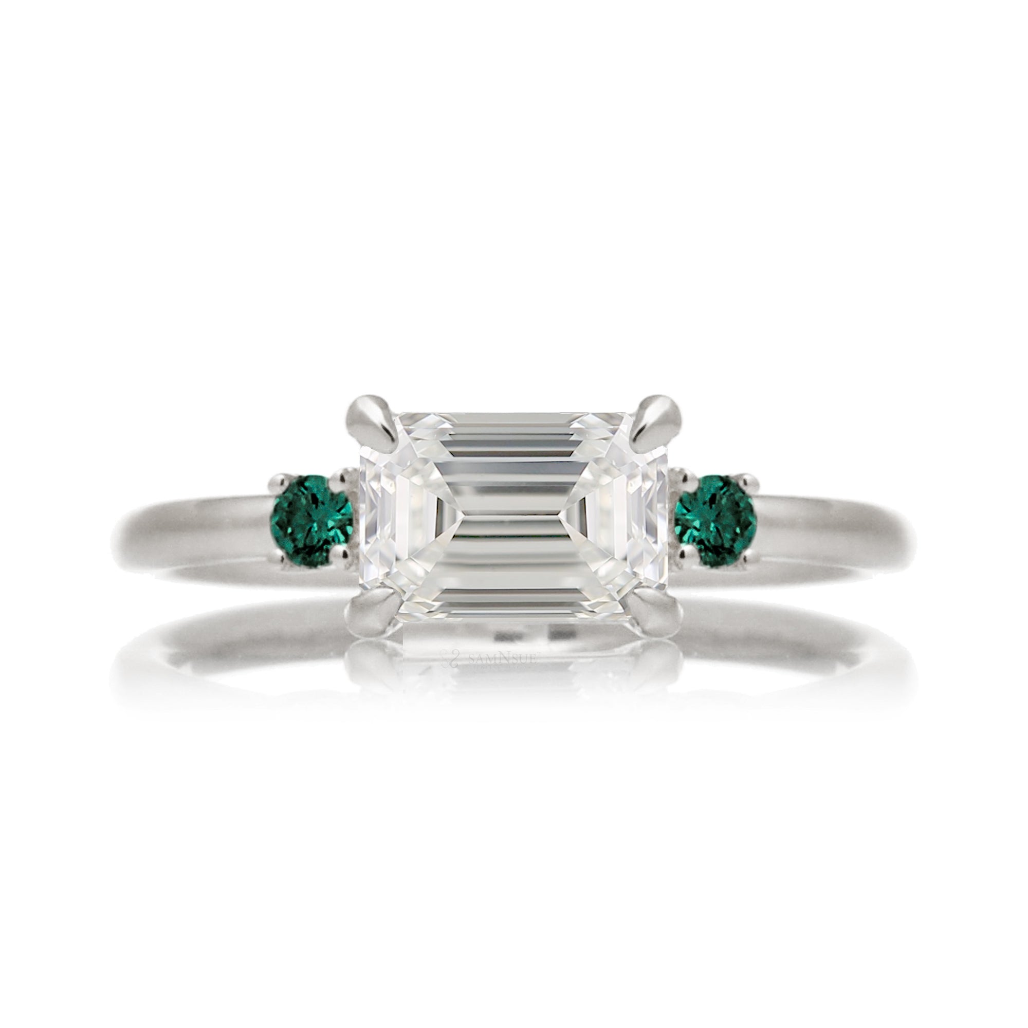 east-west emerald cut diamond three stone ring the Lena with side green emeralds white gold