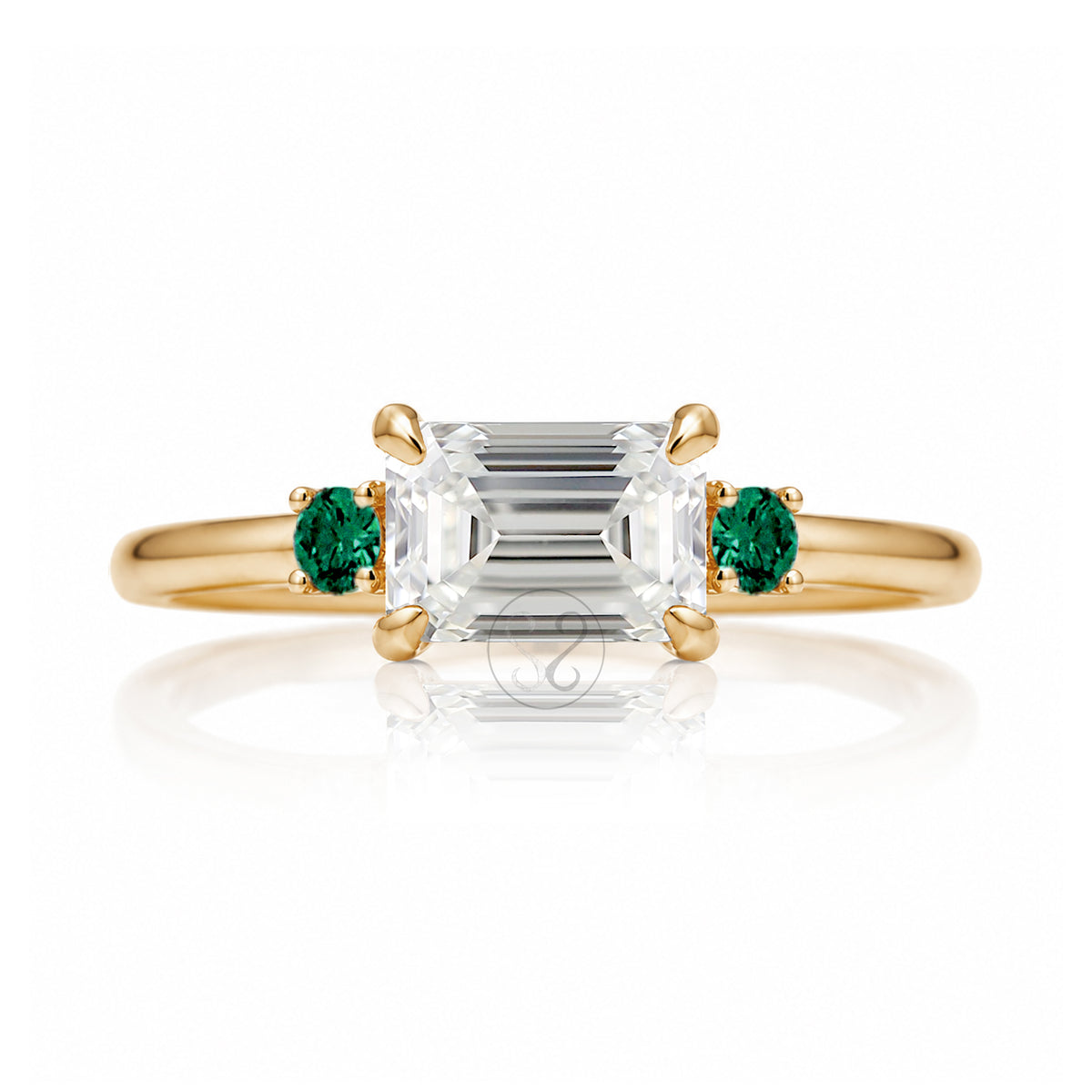 east-west emerald cut diamond three stone ring the Lena with side green emeralds yellow gold