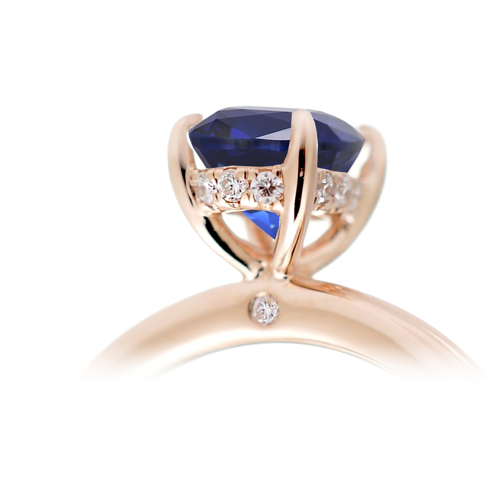 Oval cut blue sapphire engagement ring with a diamond hidden halo and solid band rose gold