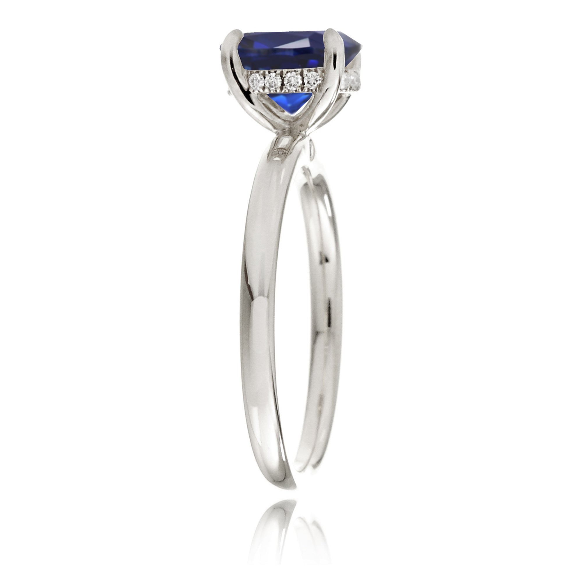 Oval cut blue sapphire engagement ring with a diamond hidden halo and solid band white gold