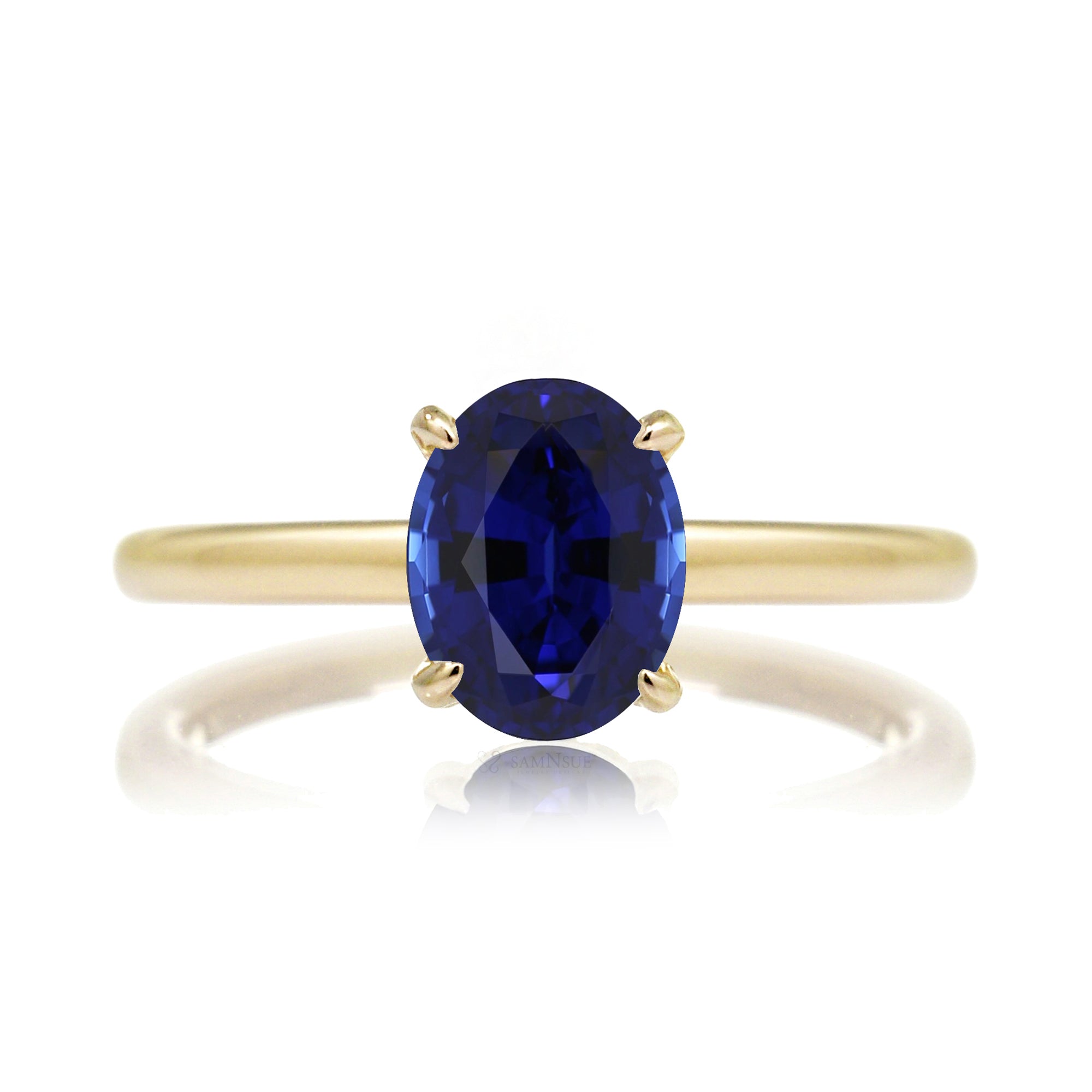 Oval cut blue sapphire engagement ring with a diamond hidden halo and solid band yellow gold