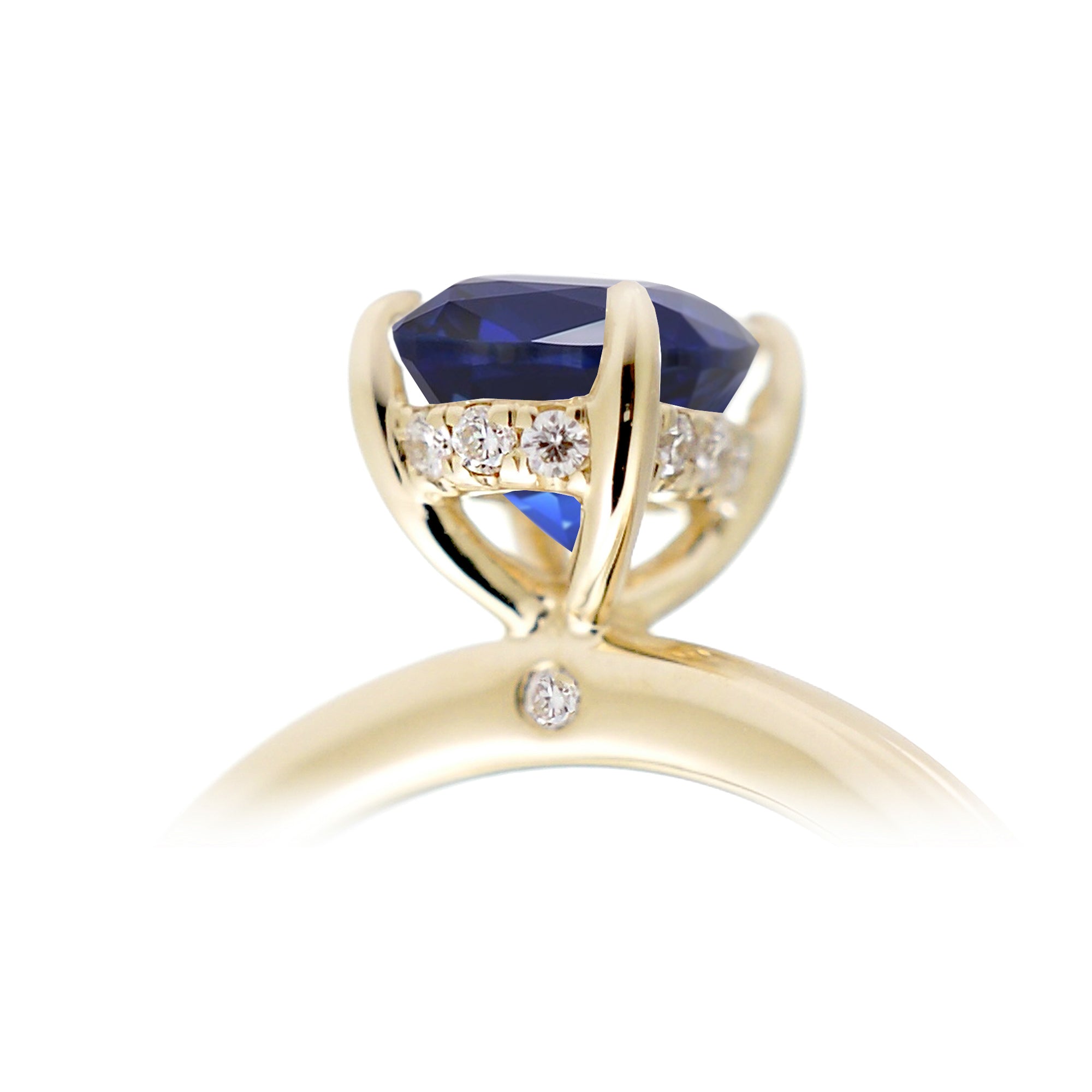 Oval cut blue sapphire engagement ring with a diamond hidden halo and solid band yellow gold