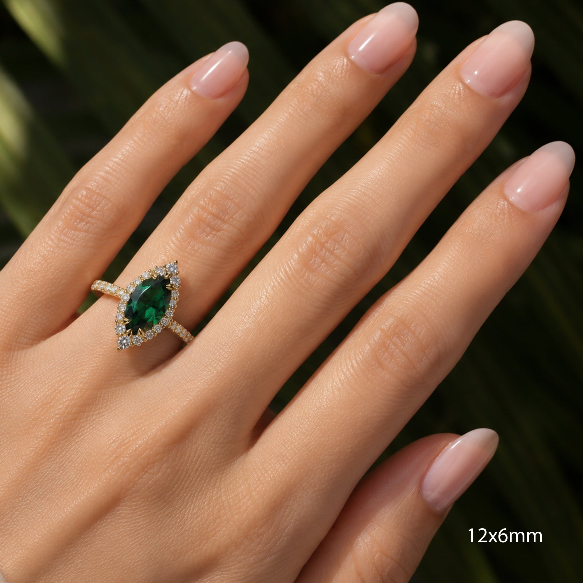 Marquise emerald with diamond halo gradual diamond band yellow gold on a hand