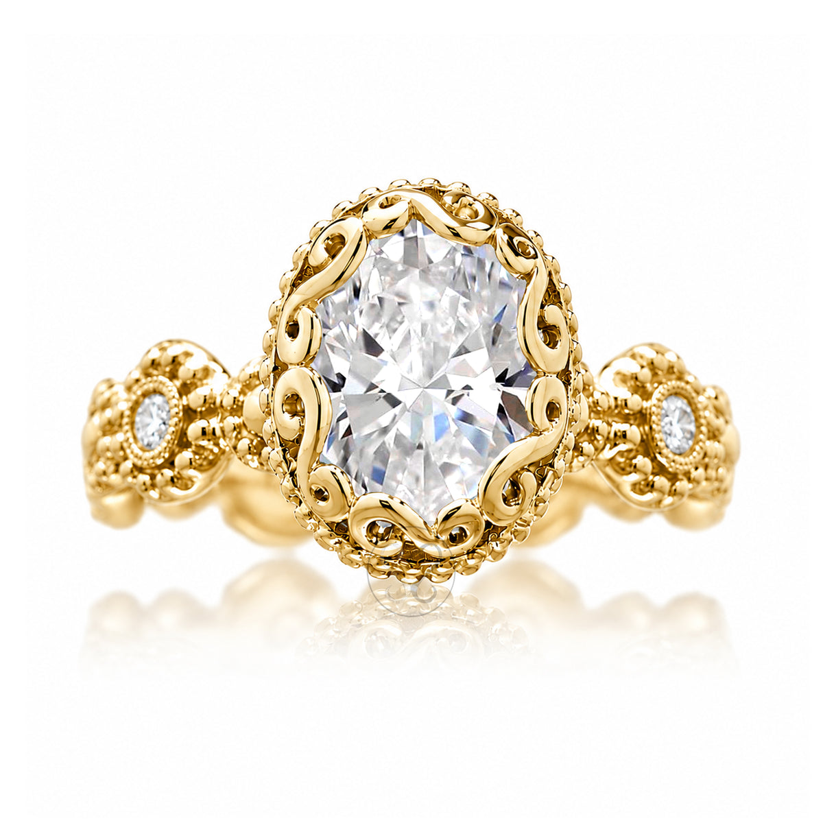 An ornate yellow gold ring featuring a large oval-cut clear center stone in a decorative filigree setting, with two smaller round stones on the band, shown on a white background with a soft reflection.