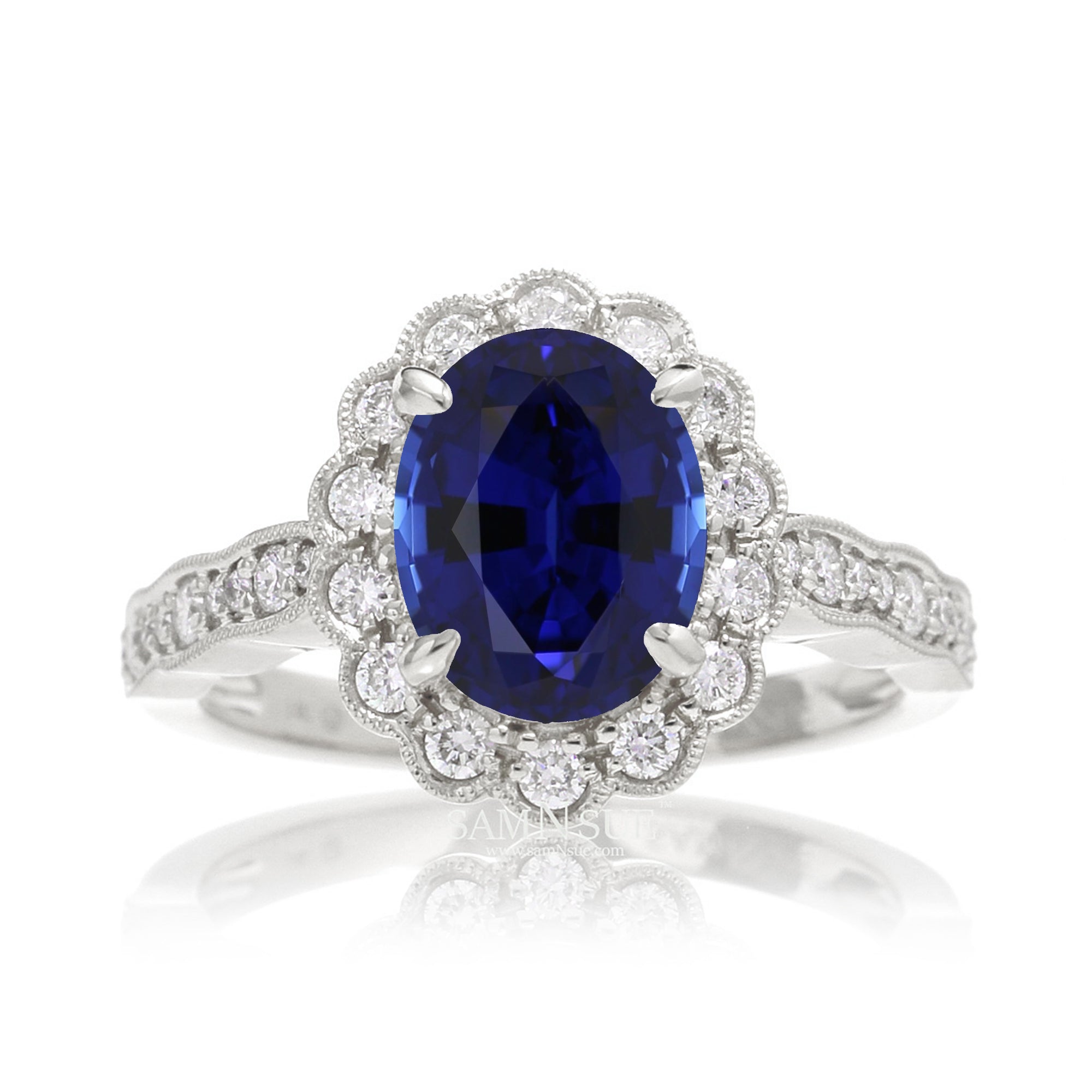Blue oval sapphire ring with diamond halo in a vintage scallop design white gold