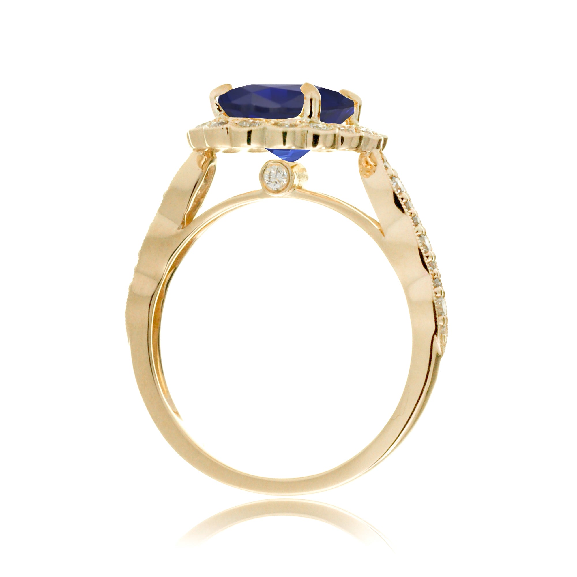 Blue oval sapphire ring with diamond halo in a vintage scallop design yellow gold