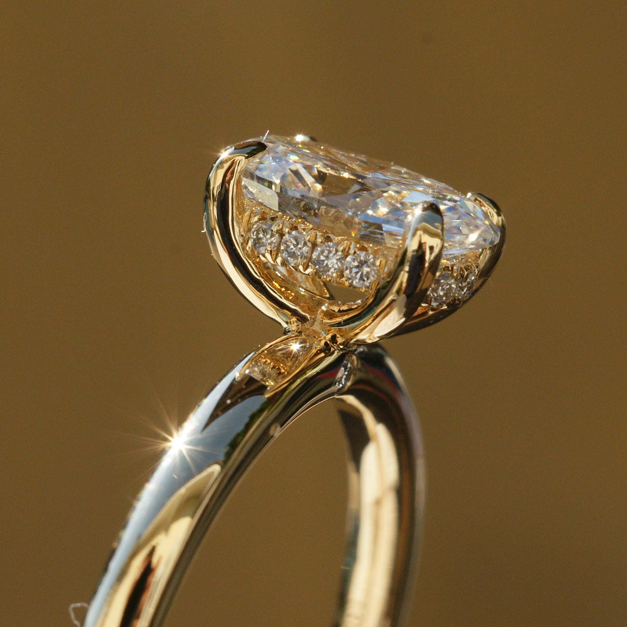 Side profile showing hidden diamond halo and detailed four-prong setting on yellow gold ring