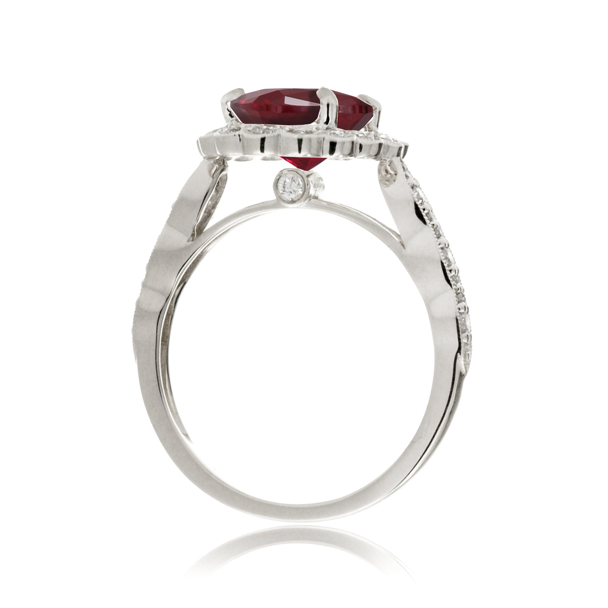 Oval cut ruby and diamond engagement ring with a vintage scallop band and halo white gold