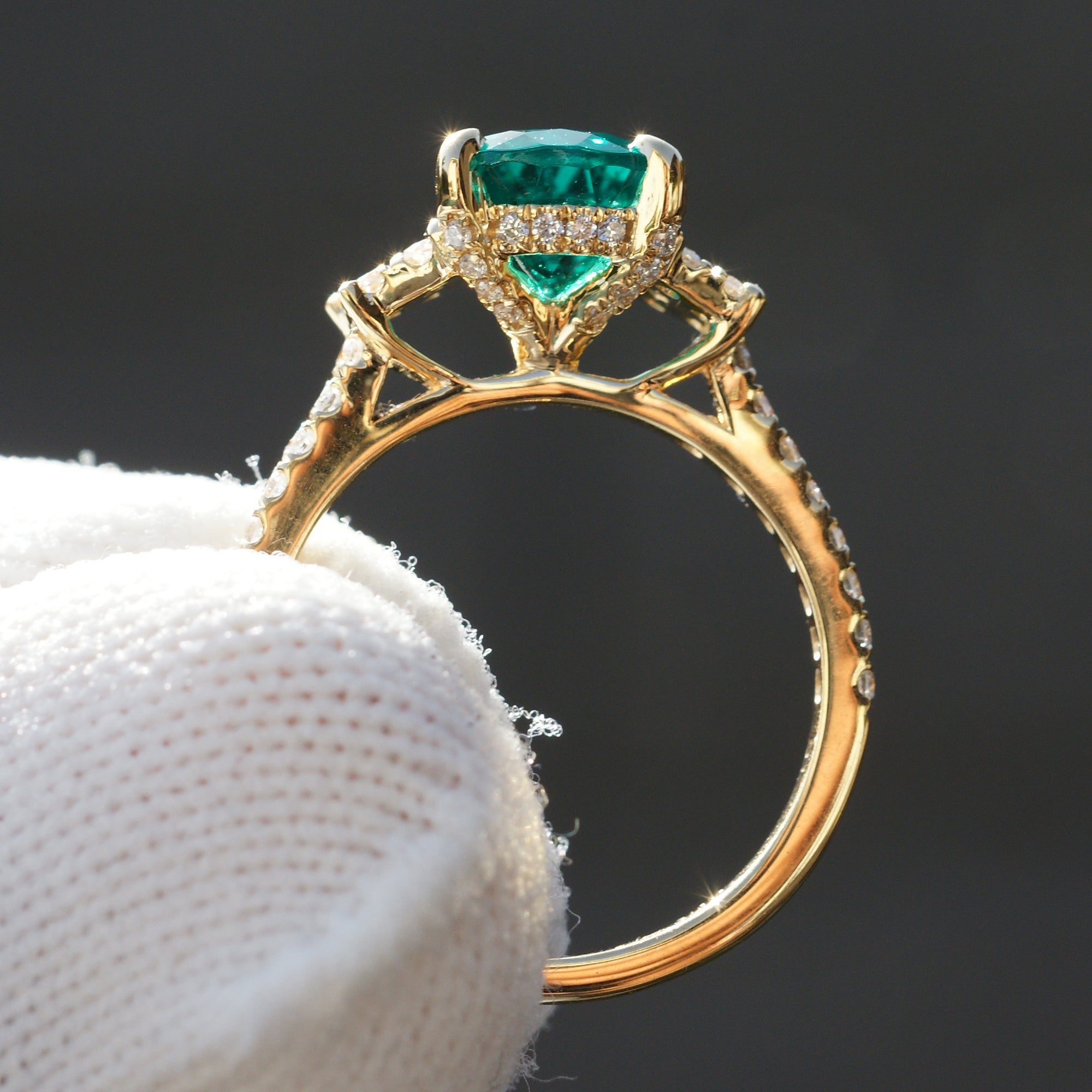 Pear emerald three stone ring with trapezoid side diamond shape in yellow gold