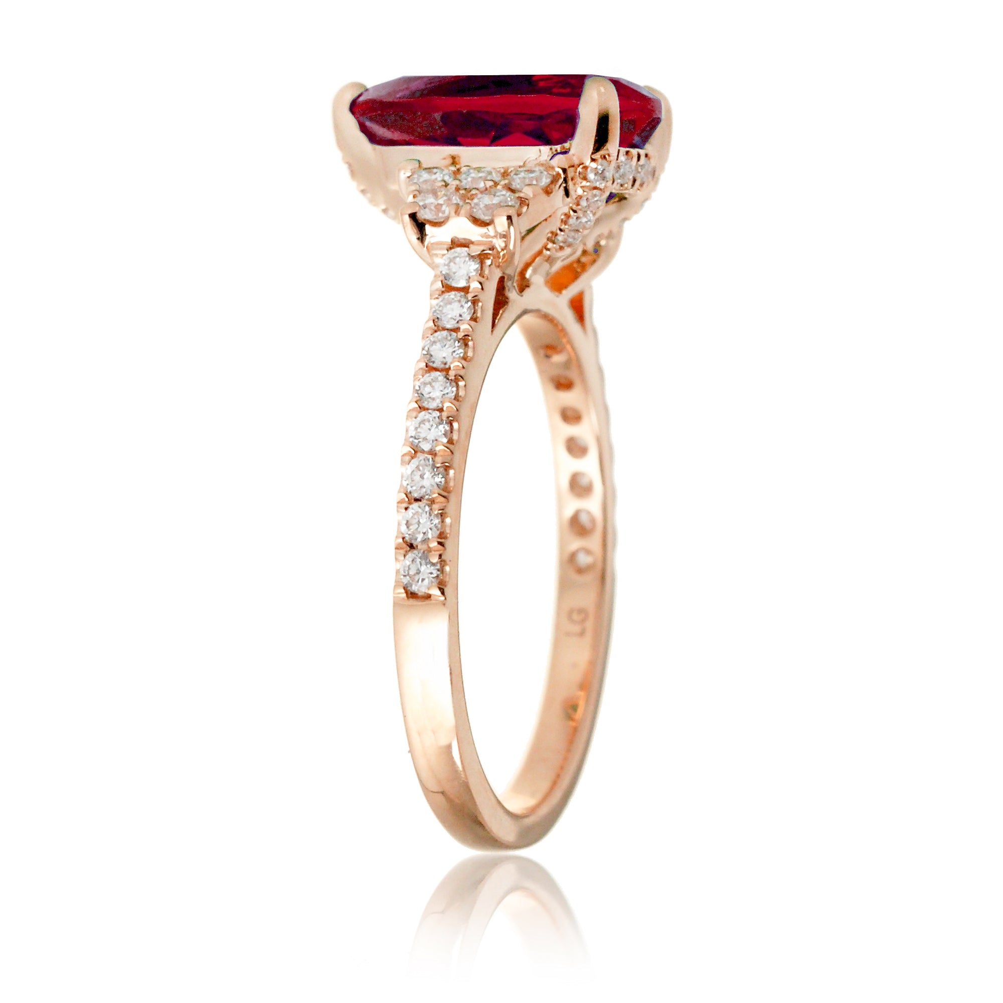 Pear cut ruby ring with trapezoid diamond side shape and band in rose gold