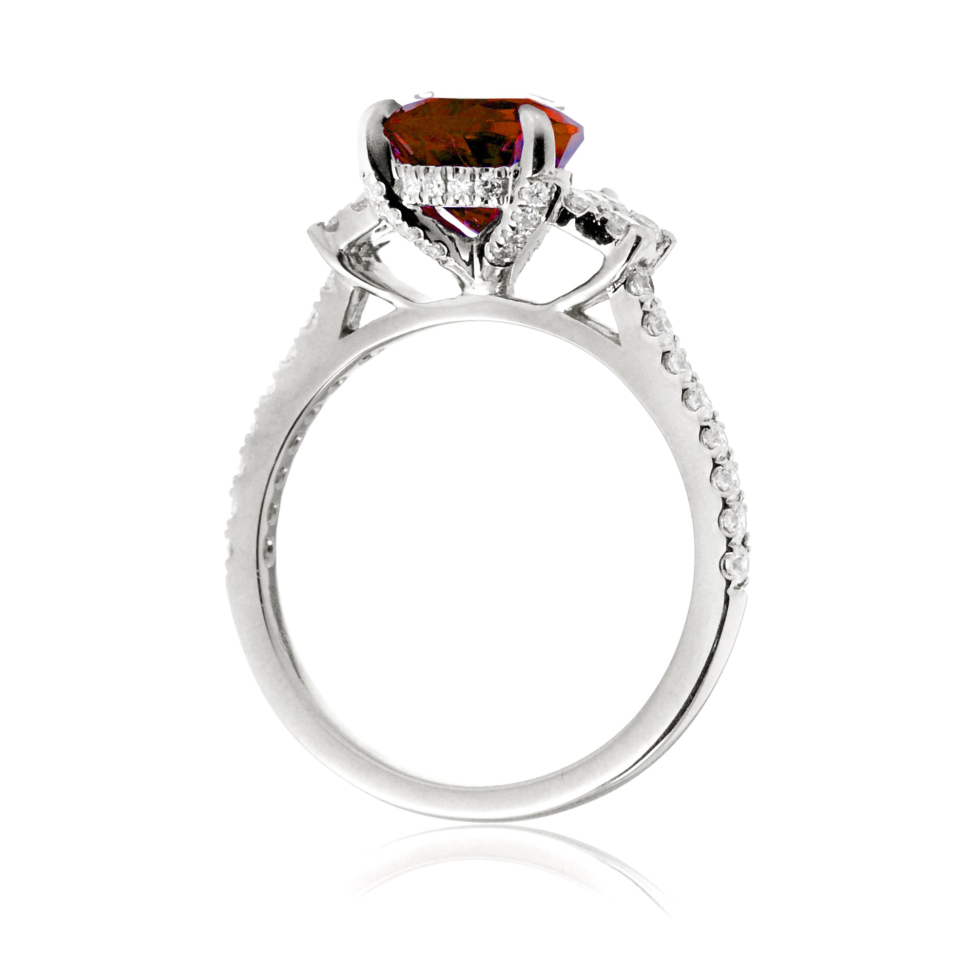 Pear cut ruby ring with trapezoid diamond side shape and band in white gold