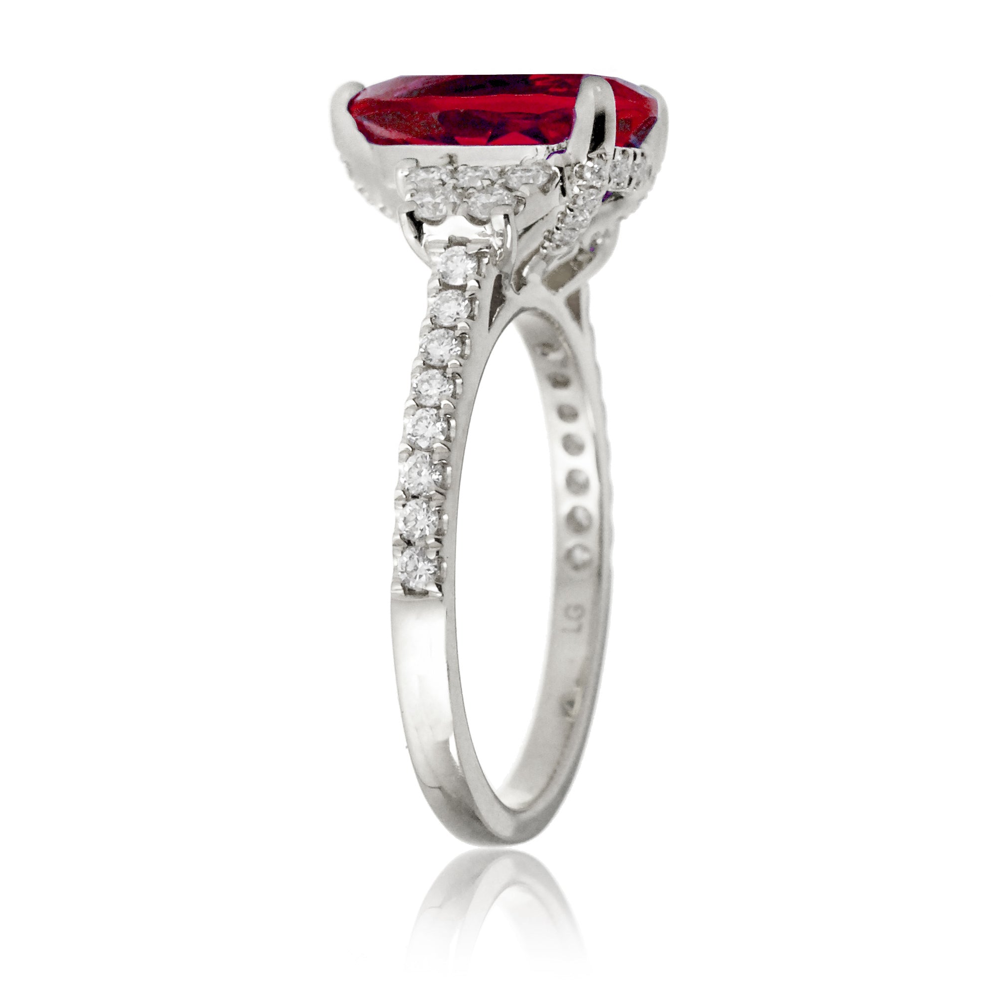 Pear cut ruby ring with trapezoid diamond side shape and band in white gold