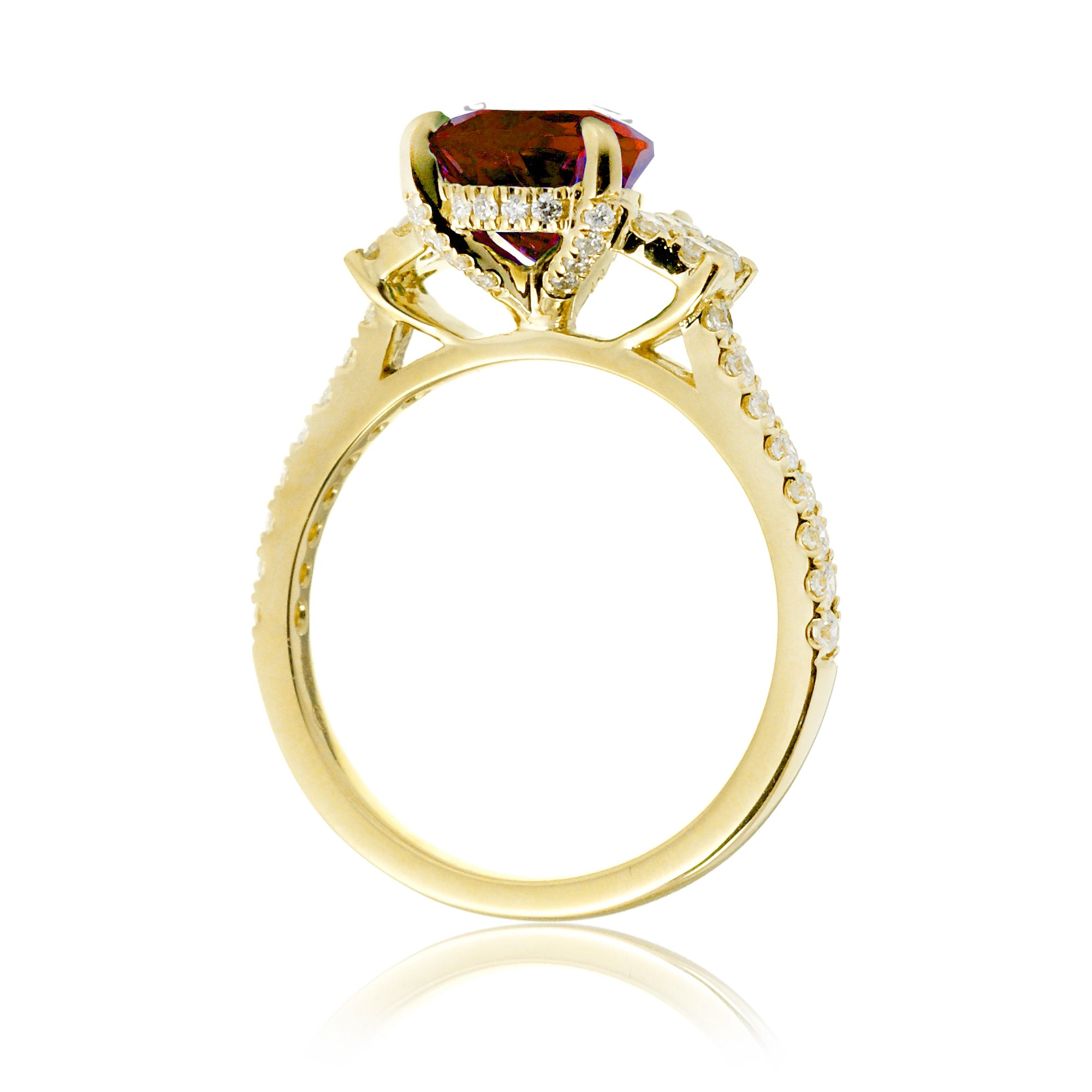 Pear cut ruby ring with trapezoid diamond side shape and band in yellow gold