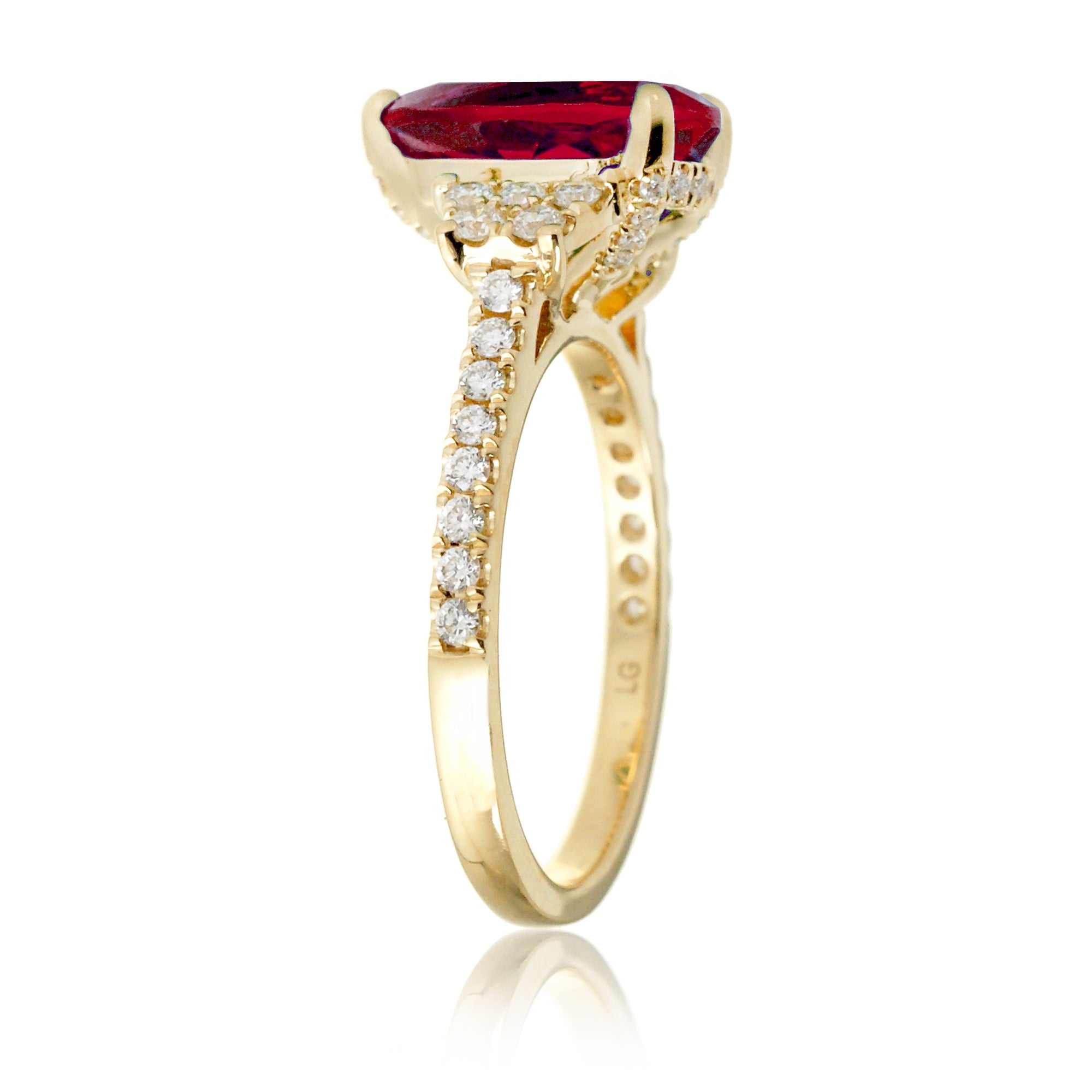 Pear cut ruby ring with trapezoid diamond side shape and band in yellow gold