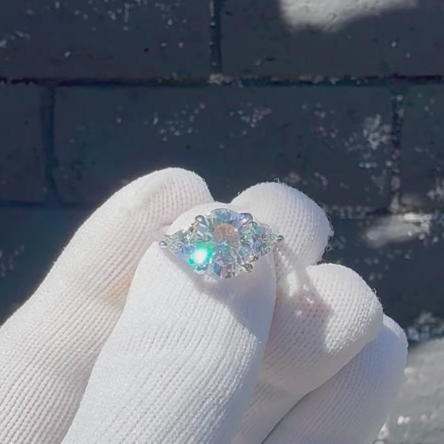Oval moissanite three stone ring with trillion on each side in white gold