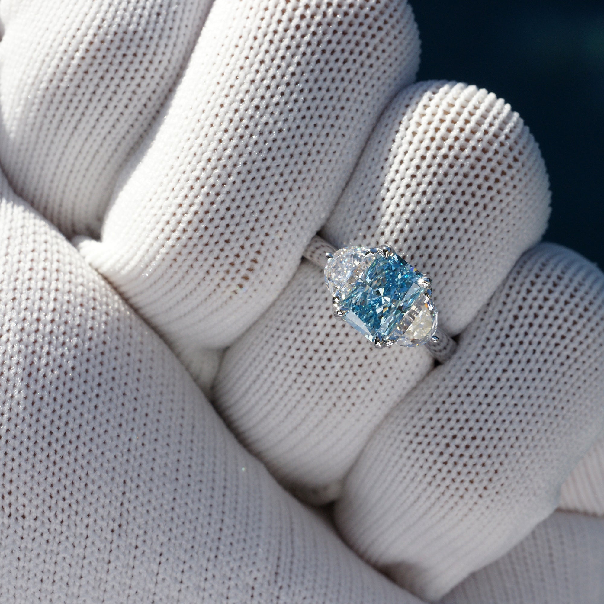 Rare fancy blue radiant cut diamond half moon three stone ring