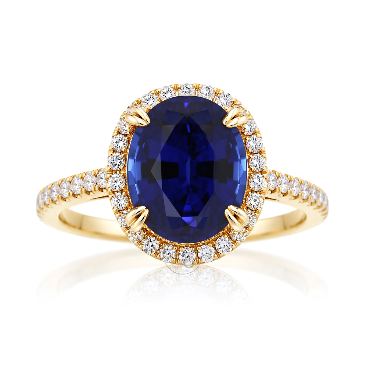 Oval blue sapphire engagement ring with diamond halo and square diamond band on a cathedral yellow gold setting