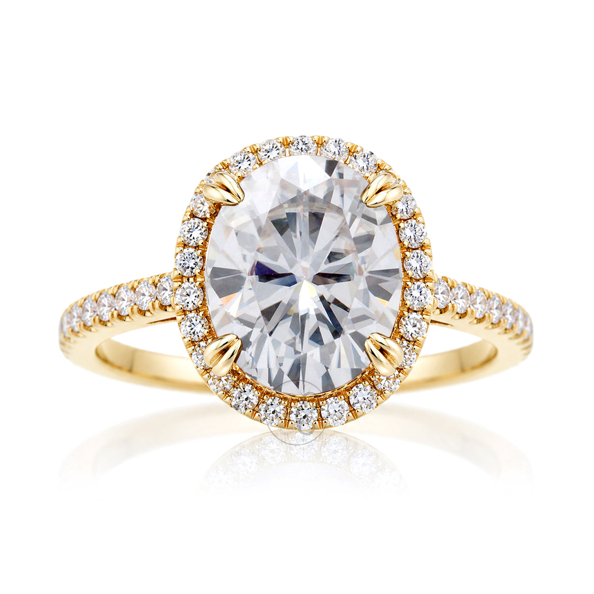 Oval moissanite engagement ring with a diamond halo and squarish diamond band on a cathedral yellow gold setting