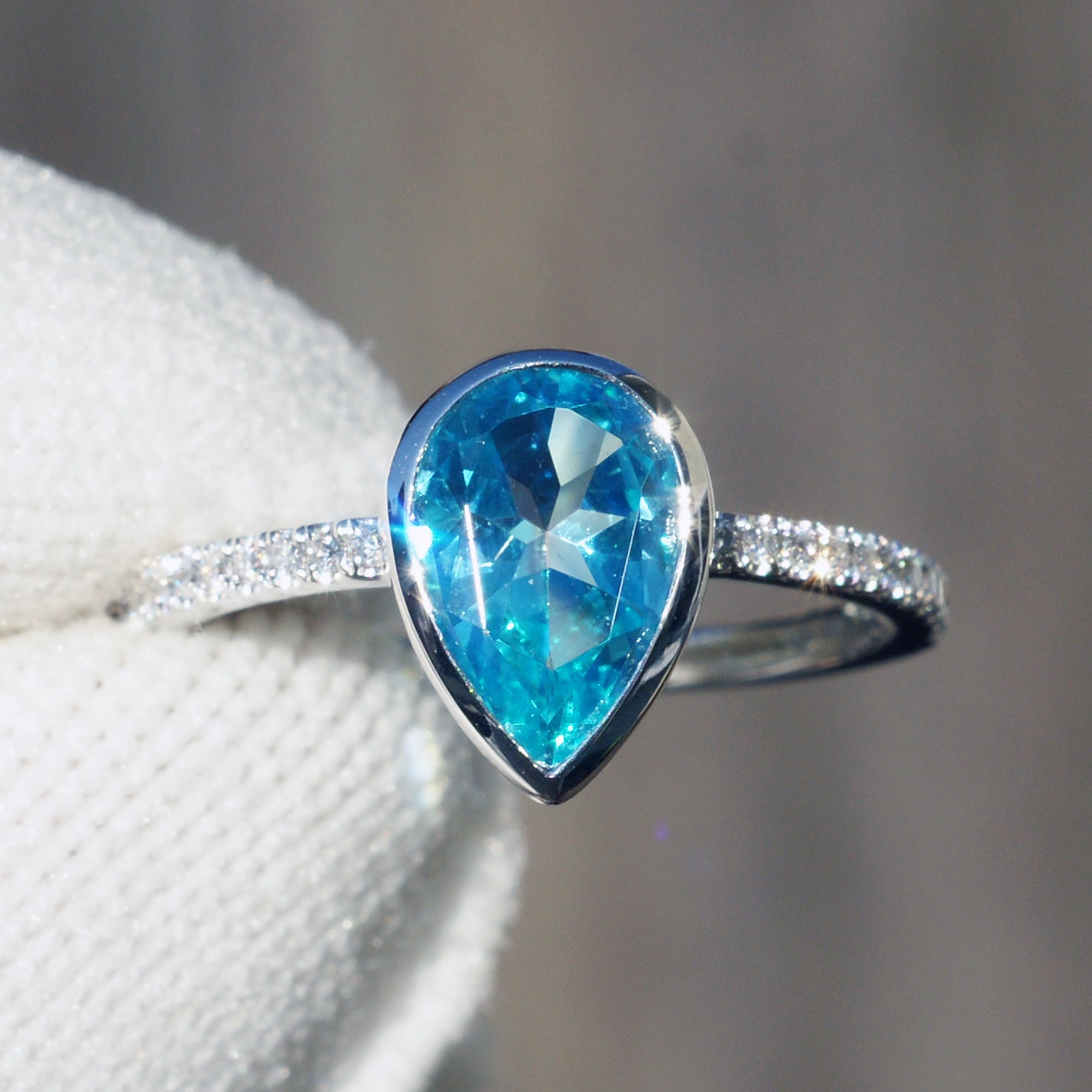 Pear cut ring Swiss blue topaz bezel set with a diamond band