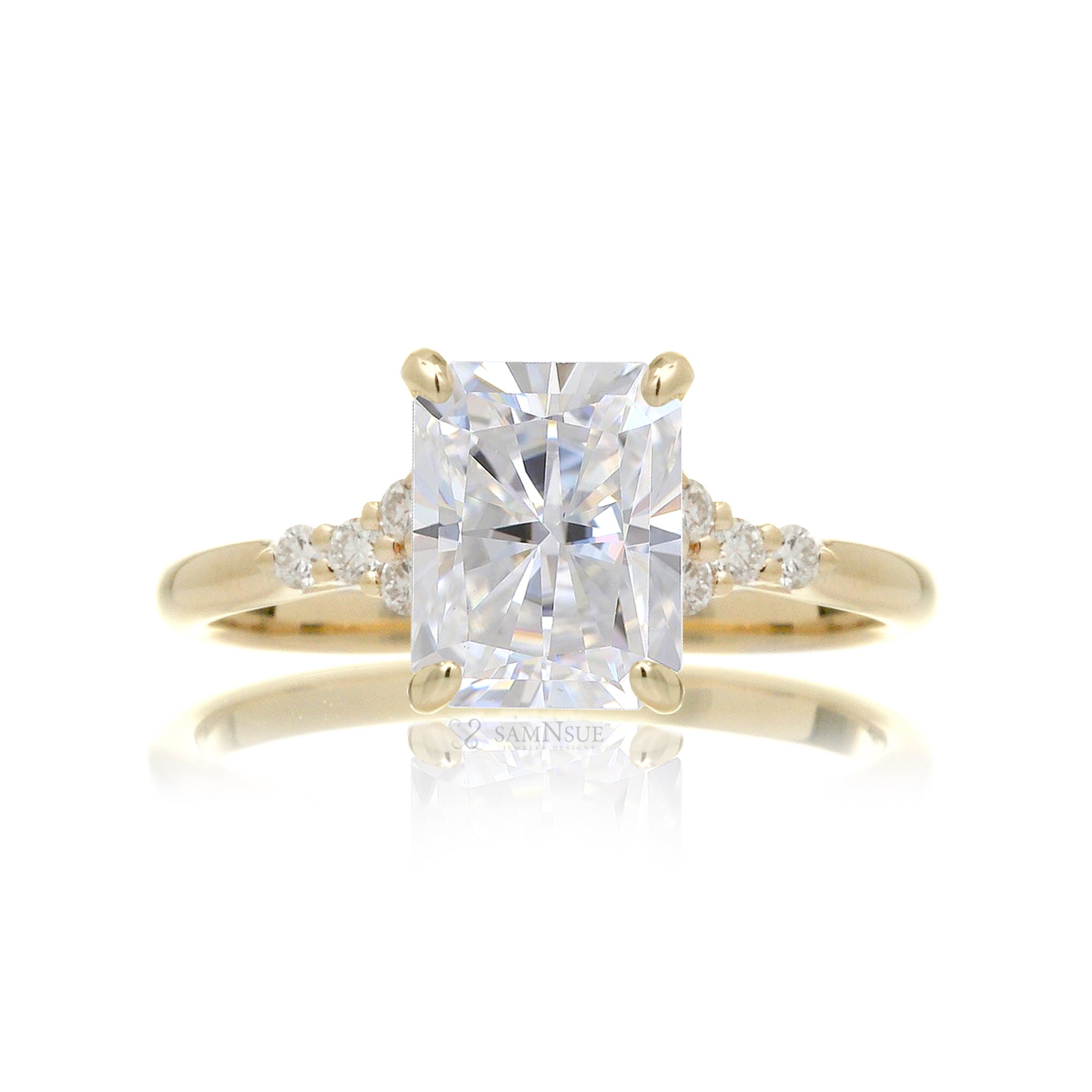 Radiant cut moissanite and diamond three stone ring in yellow gold