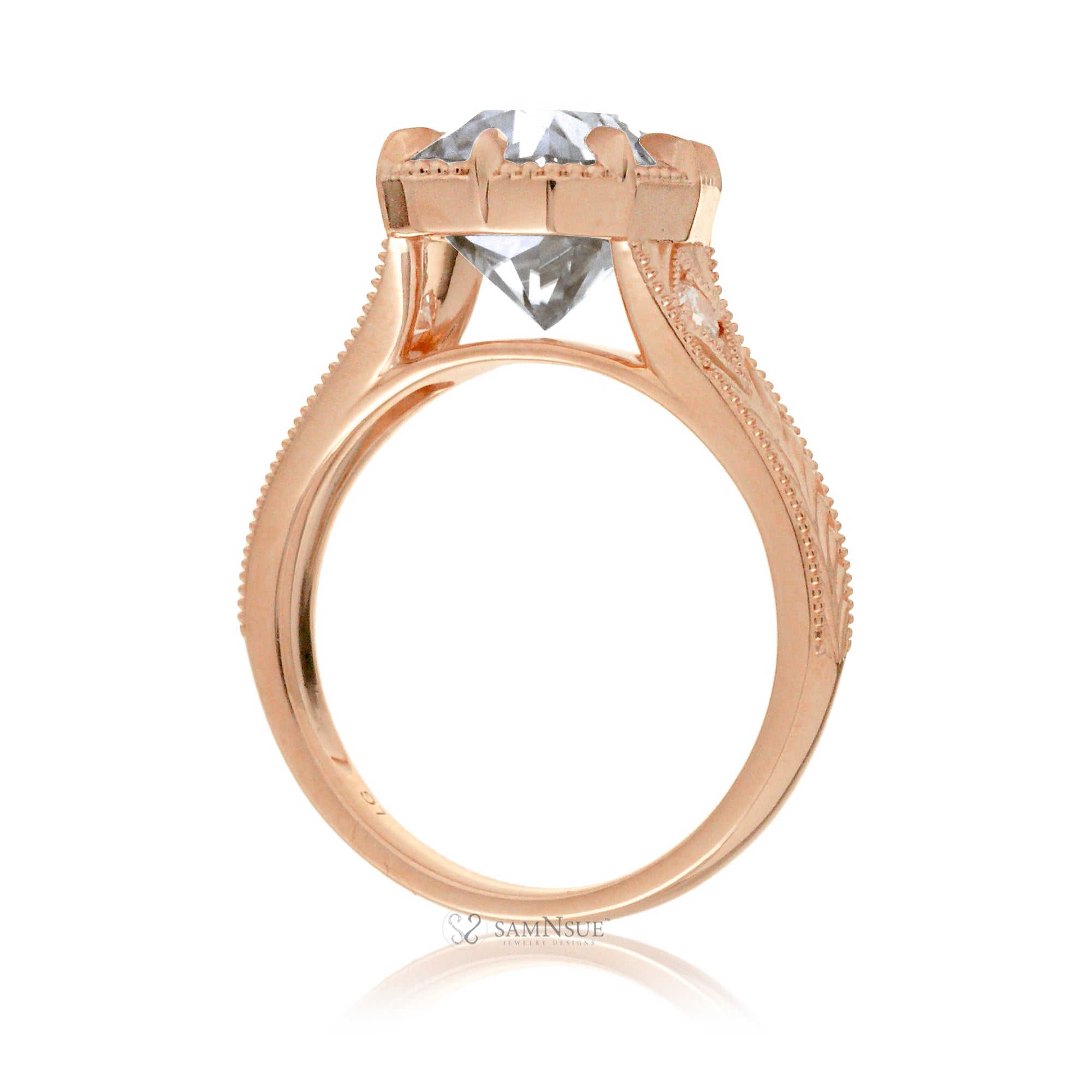 This heirloom-style ring showcases a cushion-shaped diamond with the unique facets of an old mine cut. The warm rose gold setting, paired with intricate engraving, creates a romantic design reminiscent of old-world glamour.