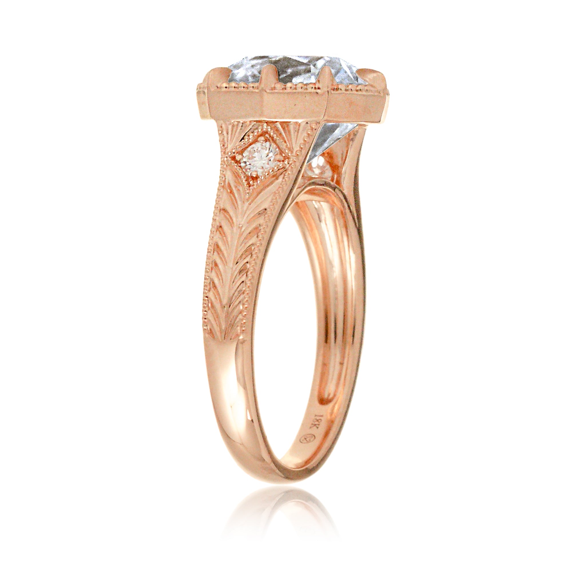 This heirloom-style ring showcases a cushion-shaped diamond with the unique facets of an old mine cut. The warm rose gold setting, paired with intricate engraving, creates a romantic design reminiscent of old-world glamour.