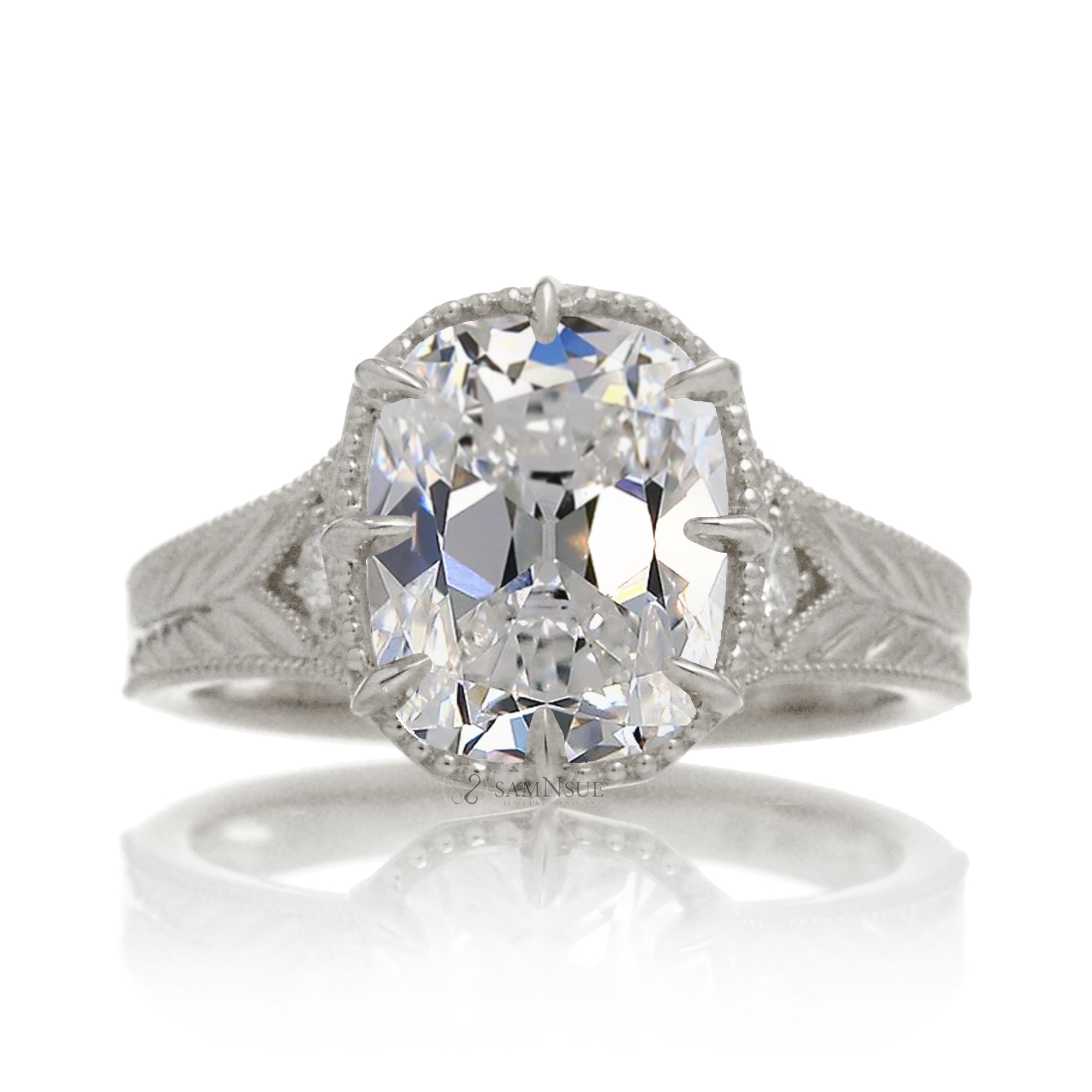 An elegant cushion diamond in an old mine cut takes center stage in this vintage-style ring. The white gold band, adorned with delicate detailing, highlights the diamond’s fire and evokes a sense of classic, enduring romance.