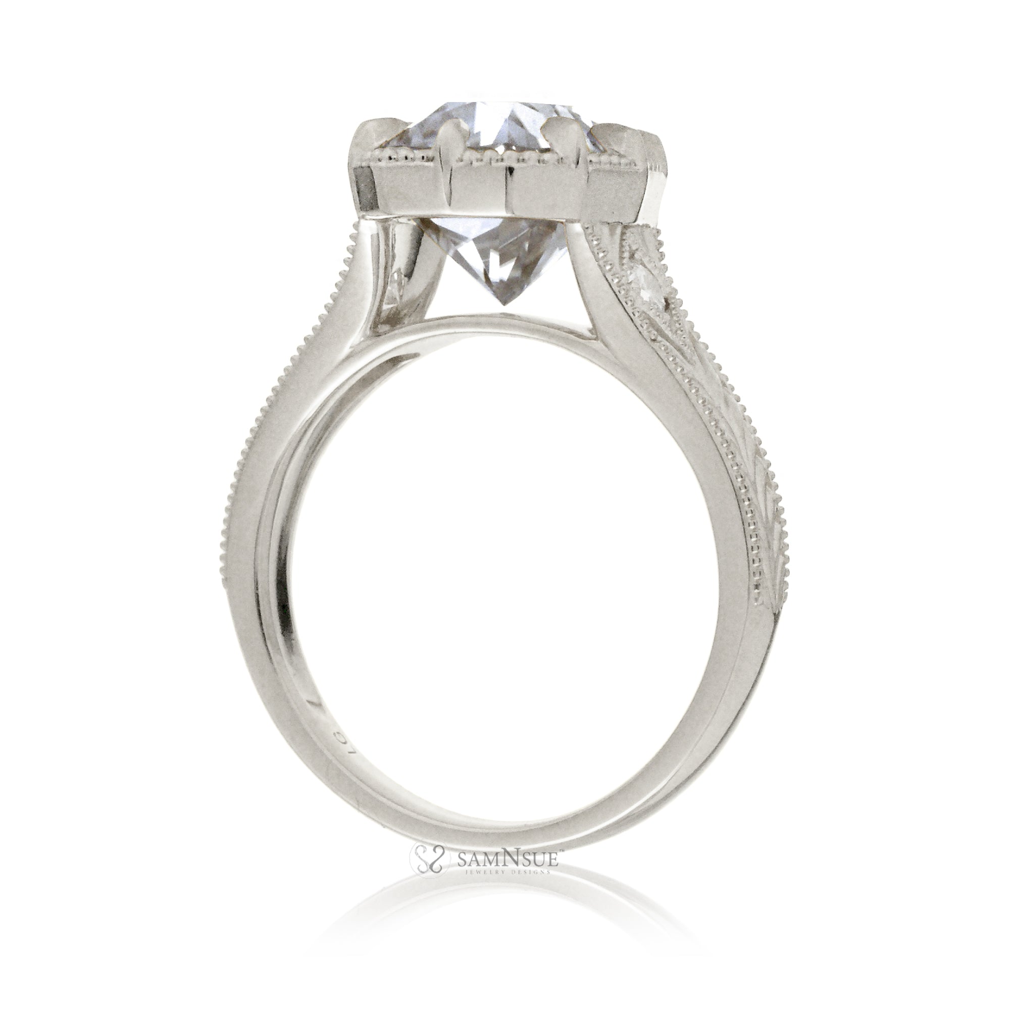 An elegant cushion diamond in an old mine cut takes center stage in this vintage-style ring. The white gold band, adorned with delicate detailing, highlights the diamond’s fire and evokes a sense of classic, enduring romance.