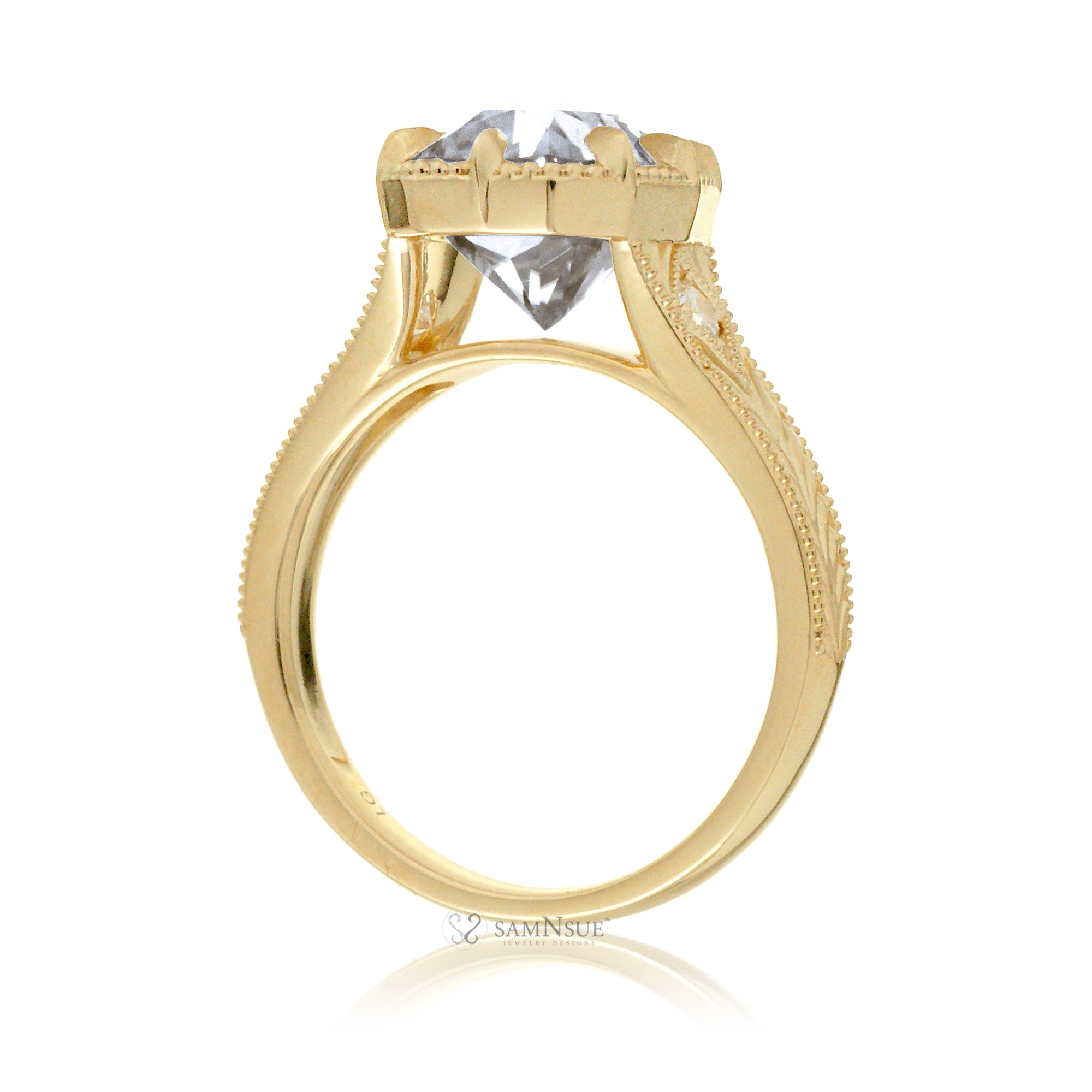 A cushion old mine cut diamond glimmers at the heart of this vintage-inspired engagement ring, set in polished yellow gold. The detailed band features hand-carved artistry, enhancing the antique character and timeless appeal.