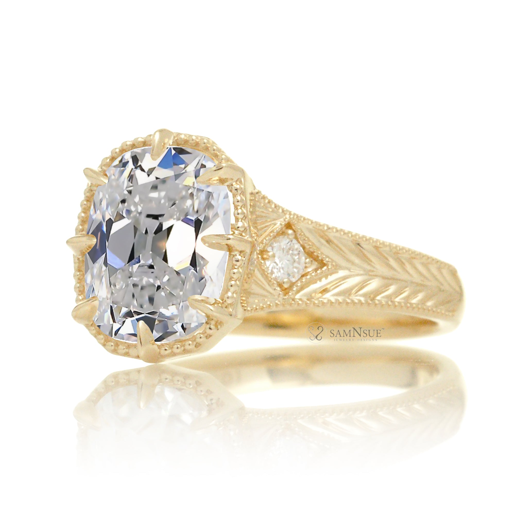A cushion old mine cut diamond glimmers at the heart of this vintage-inspired engagement ring, set in polished yellow gold. The detailed band features hand-carved artistry, enhancing the antique character and timeless appeal.