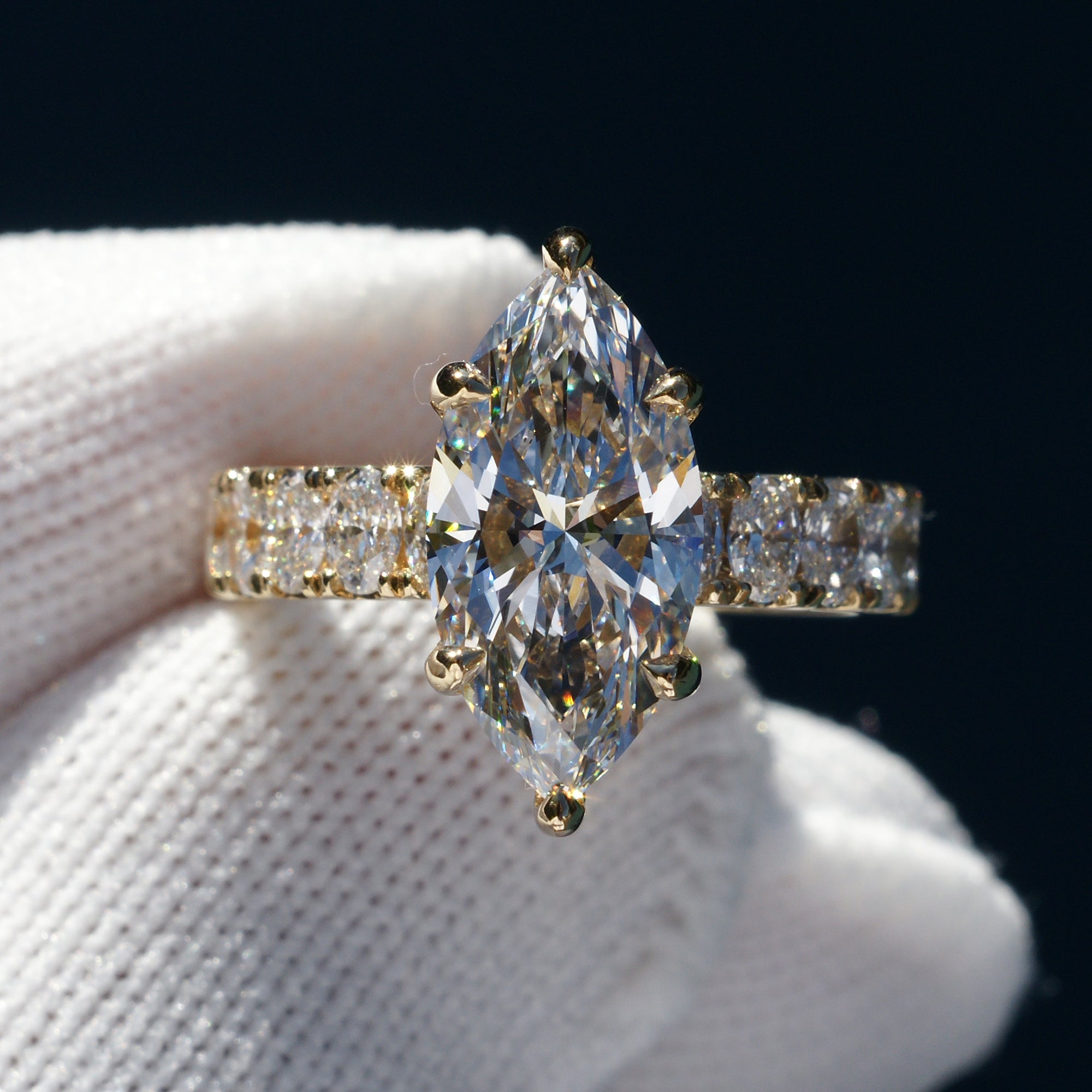 Marquise cut diamond engagement ring with oval diamond band and six prongs yellow gold