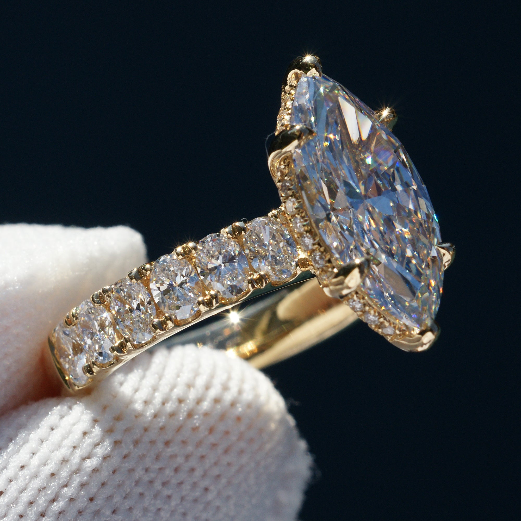Marquise cut diamond engagement ring with oval diamond band and six prongs yellow gold