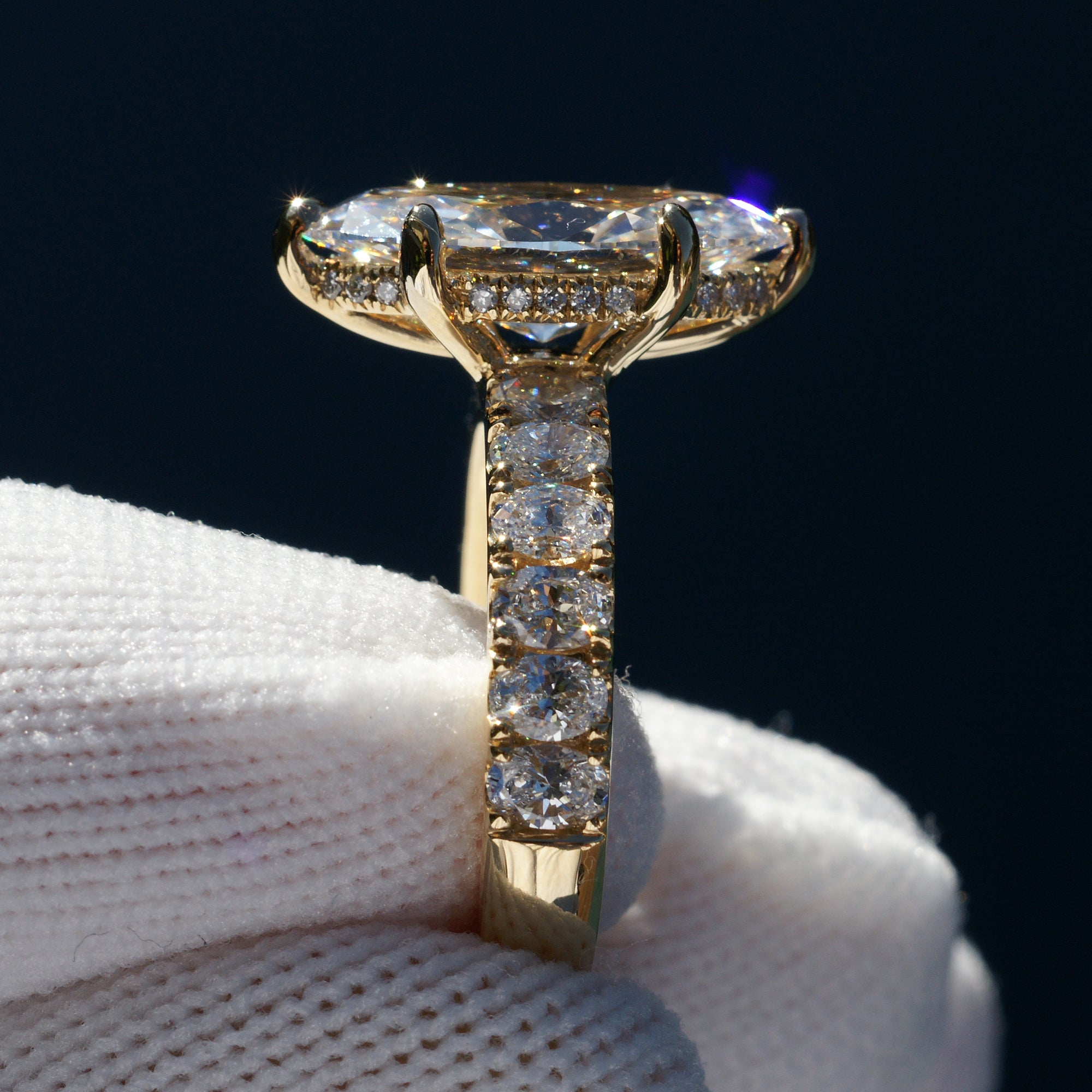 Marquise cut diamond engagement ring with oval diamond band and six prongs yellow gold