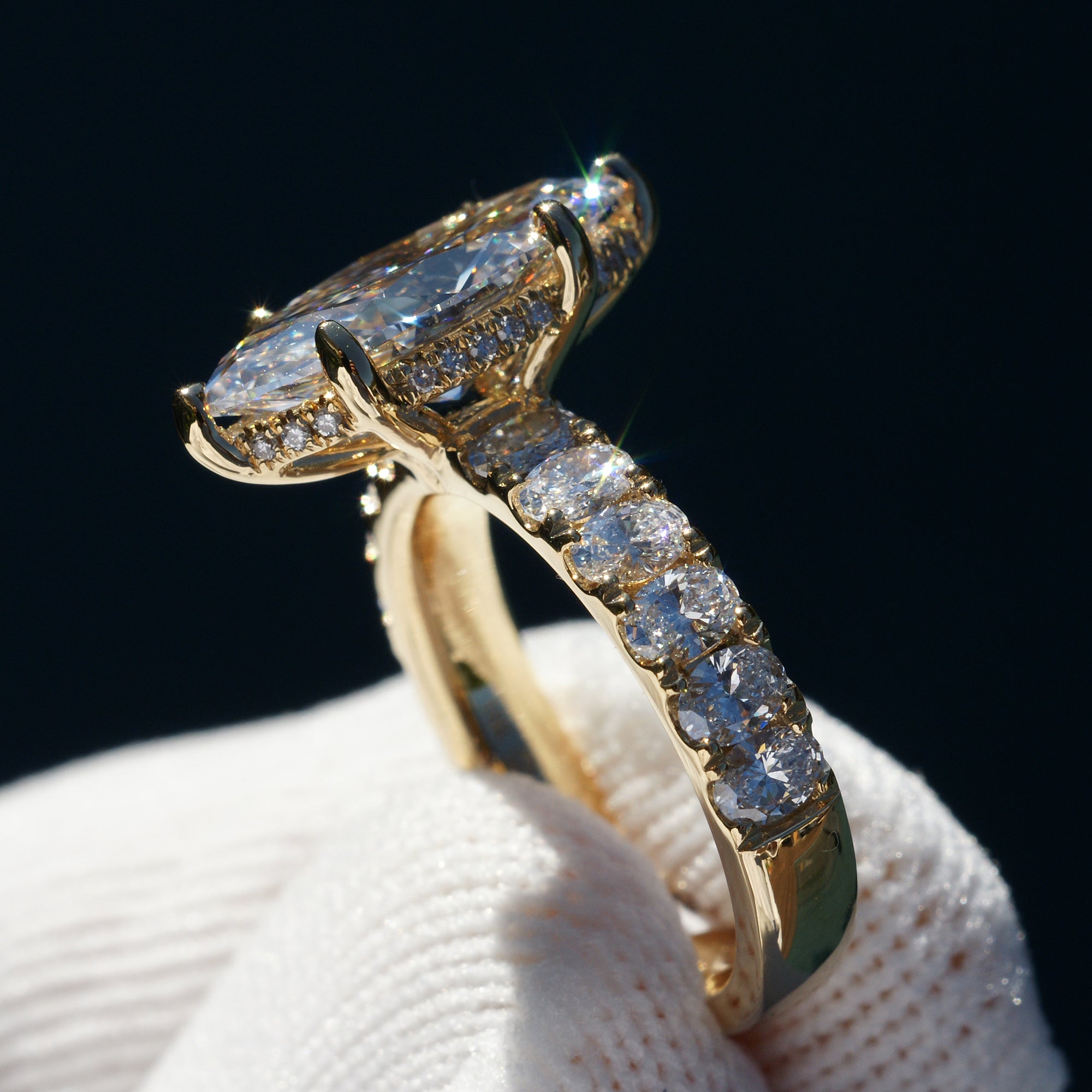 Marquise cut diamond engagement ring with oval diamond band and six prongs yellow gold