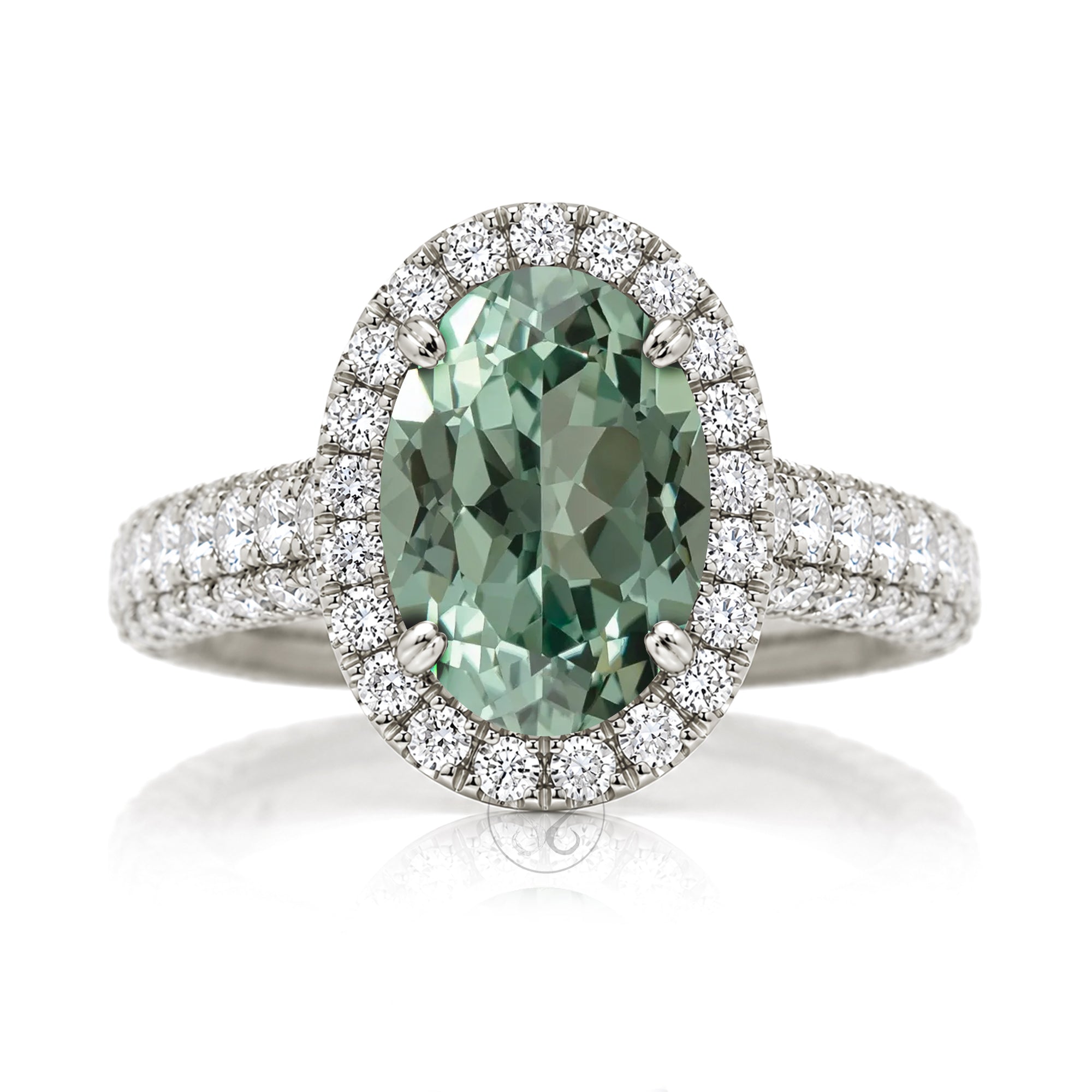 Oval-cut green sapphire engagement ring in white gold with diamond halo and pavé diamond shoulders