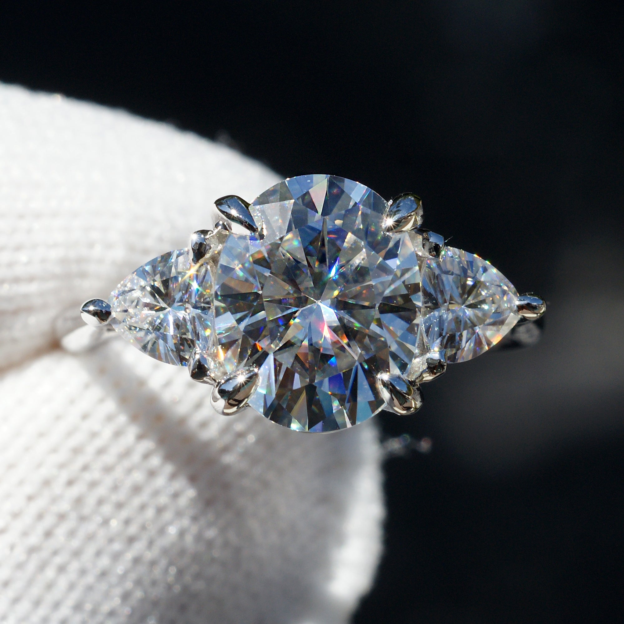 Oval moissanite three stone ring with trillion on each side in white gold