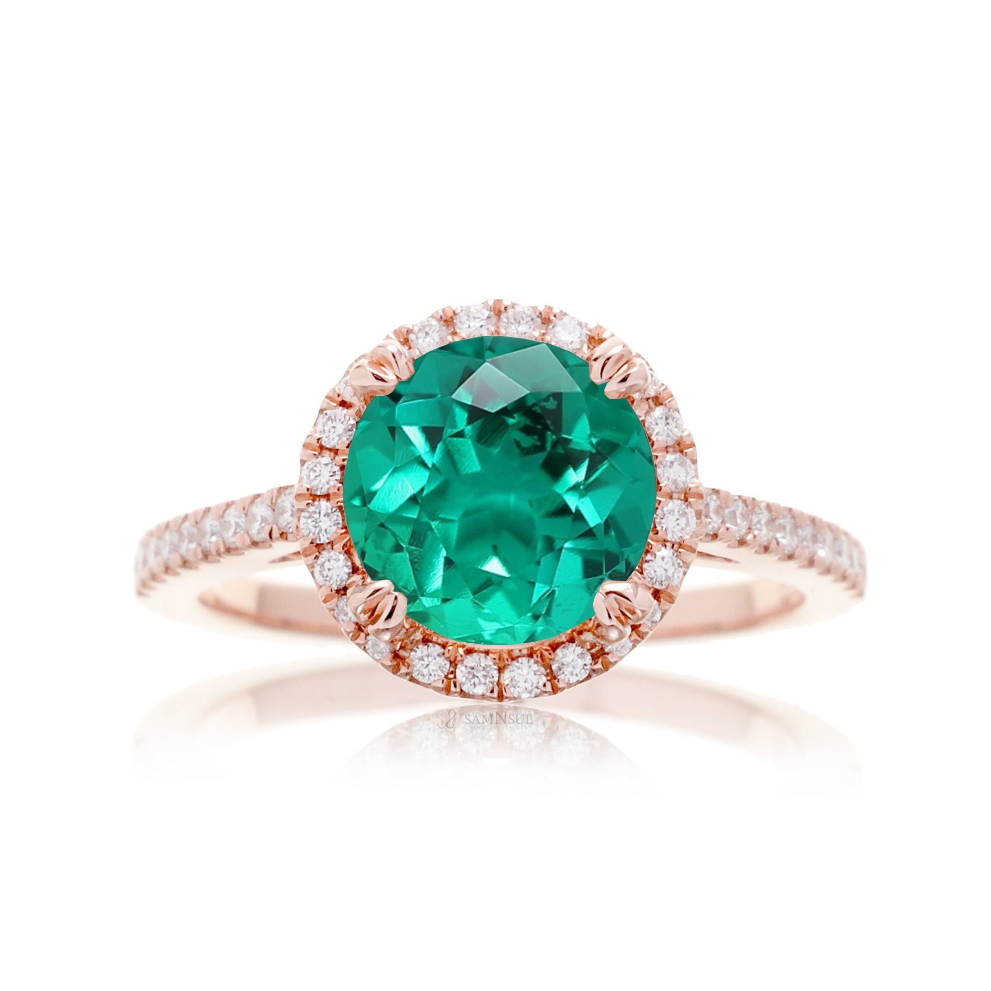 Round cut emerald ring with a diamond halo in rose gold