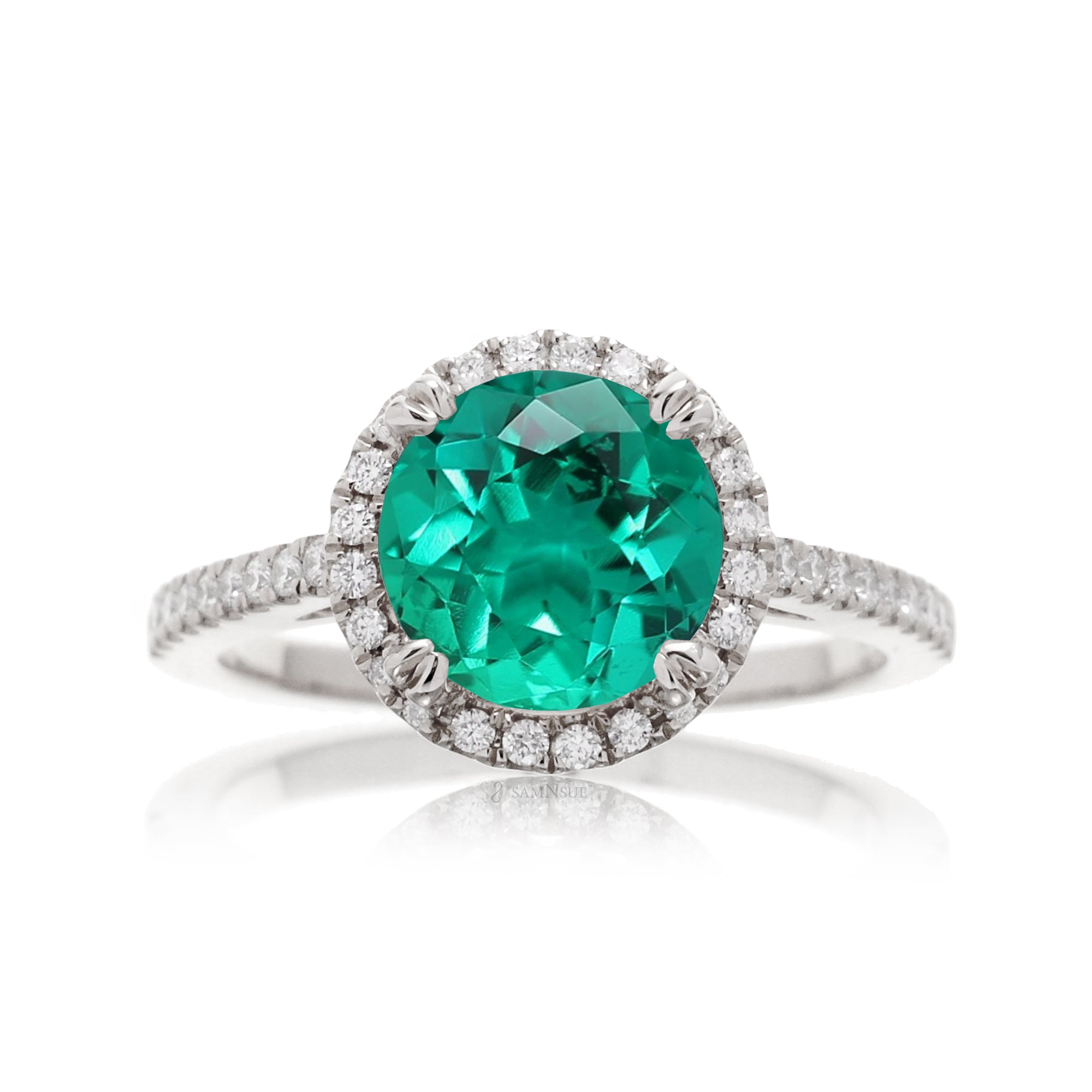 Round cut emerald ring with a diamond halo in white gold