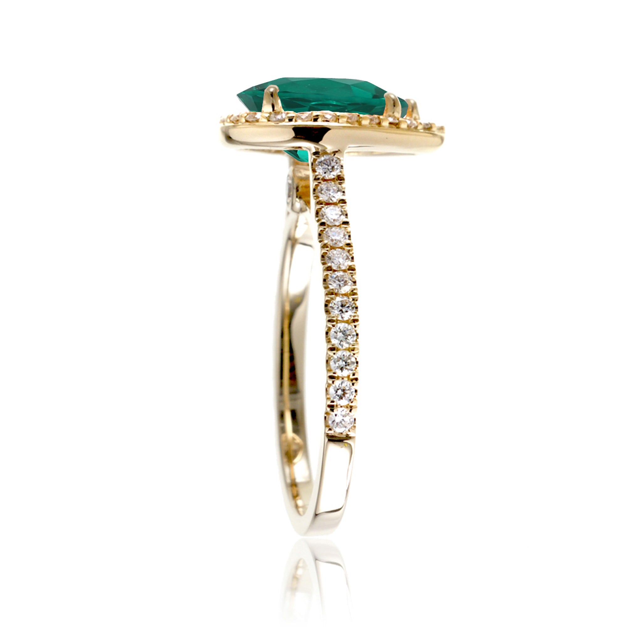 Pear emerald with diamond halo and band hidden bezel in yellow gold