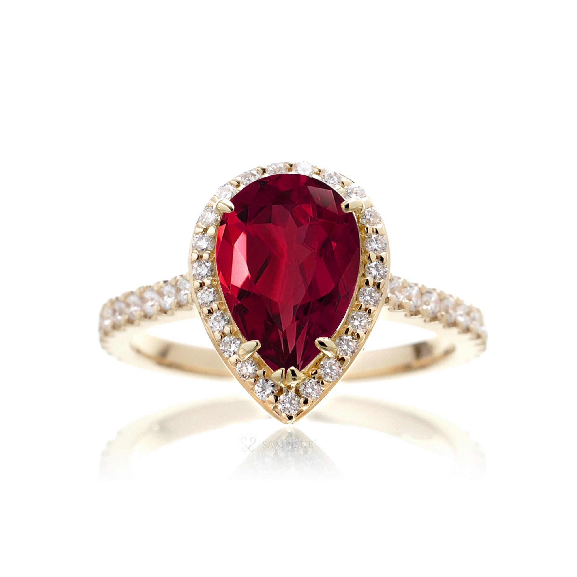 Pear ruby engagement ring with diamond halo and diamond band yellow gold