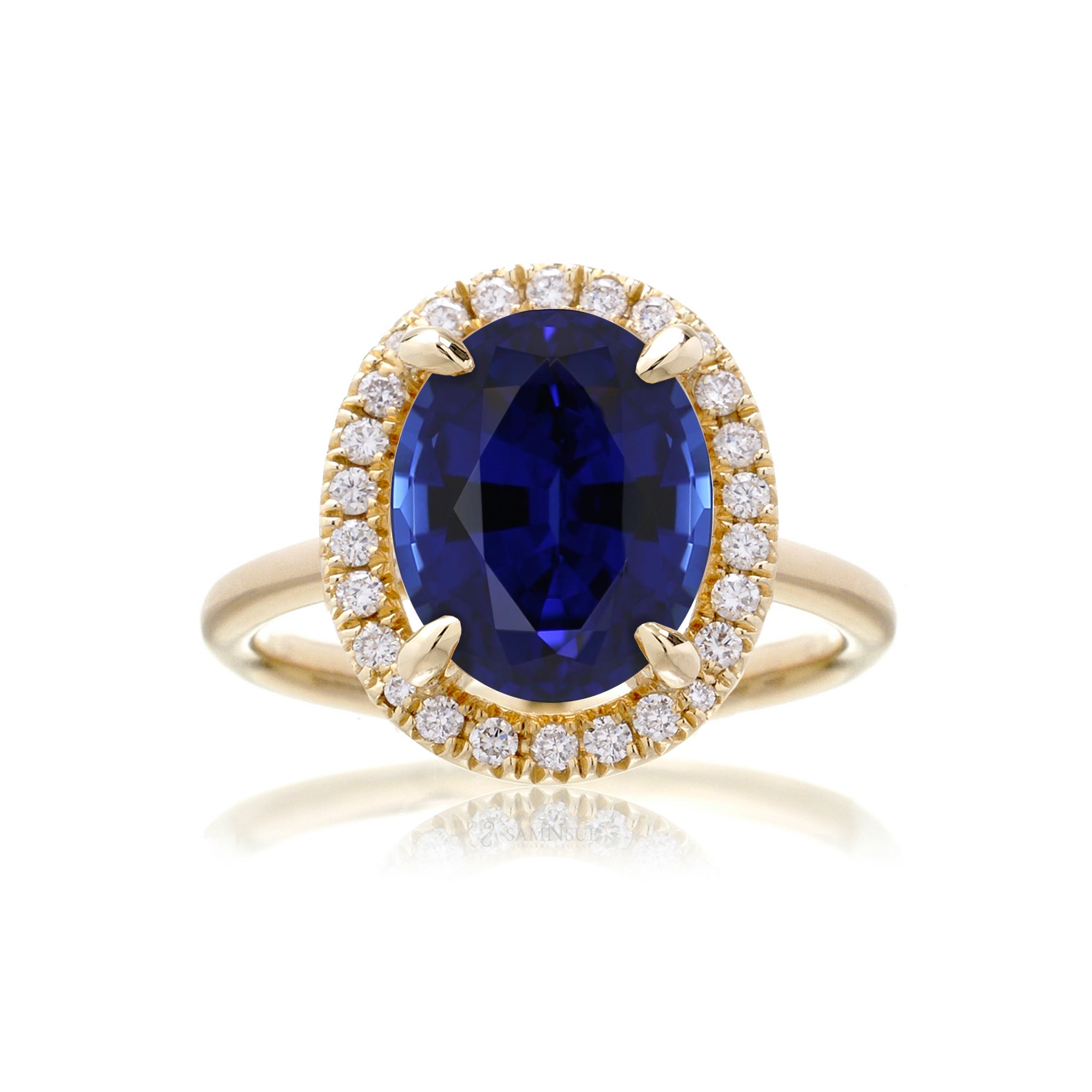 Oval blue sapphire ring with solid band and diamond halo in yellow gold