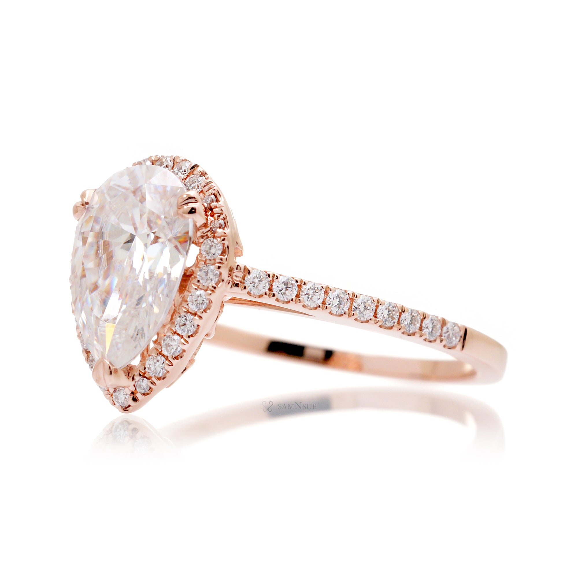 Pear moissanite and diamond halo ring in the signature rose gold