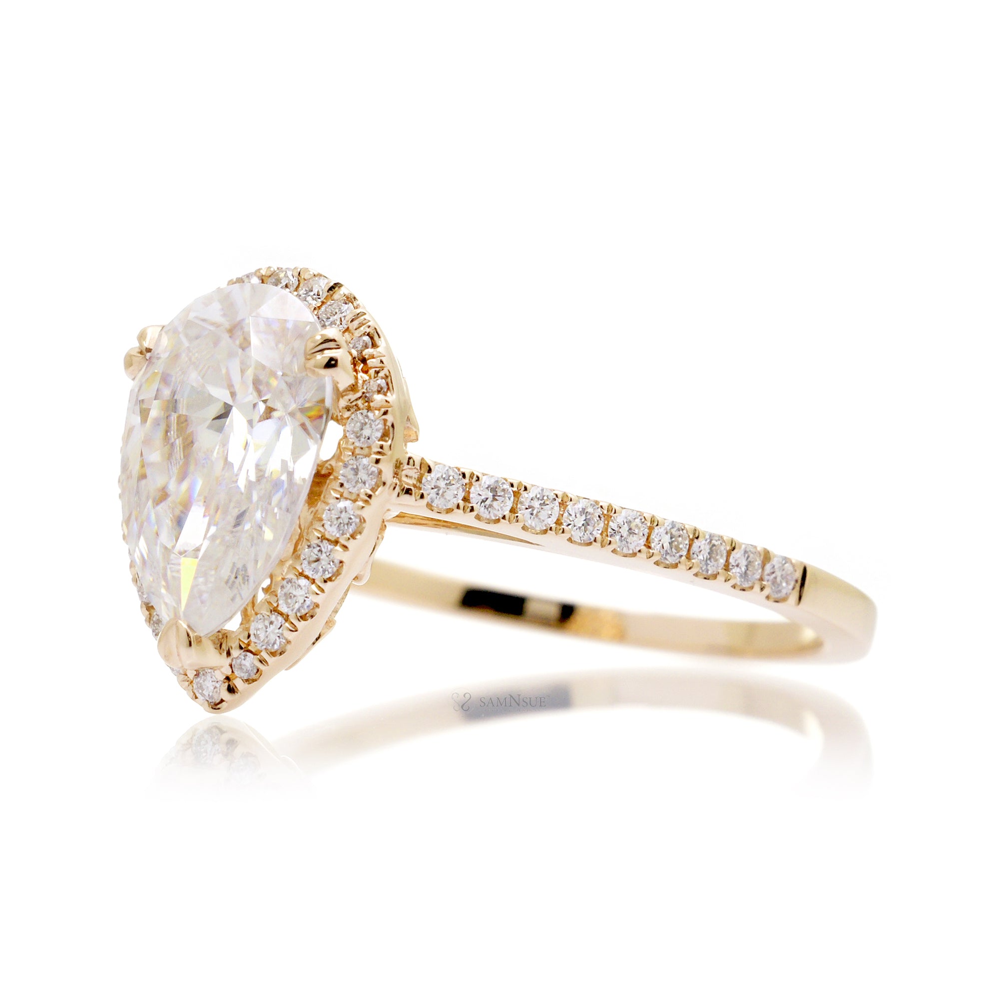 Pear moissanite and diamond halo ring in the signature yellow gold